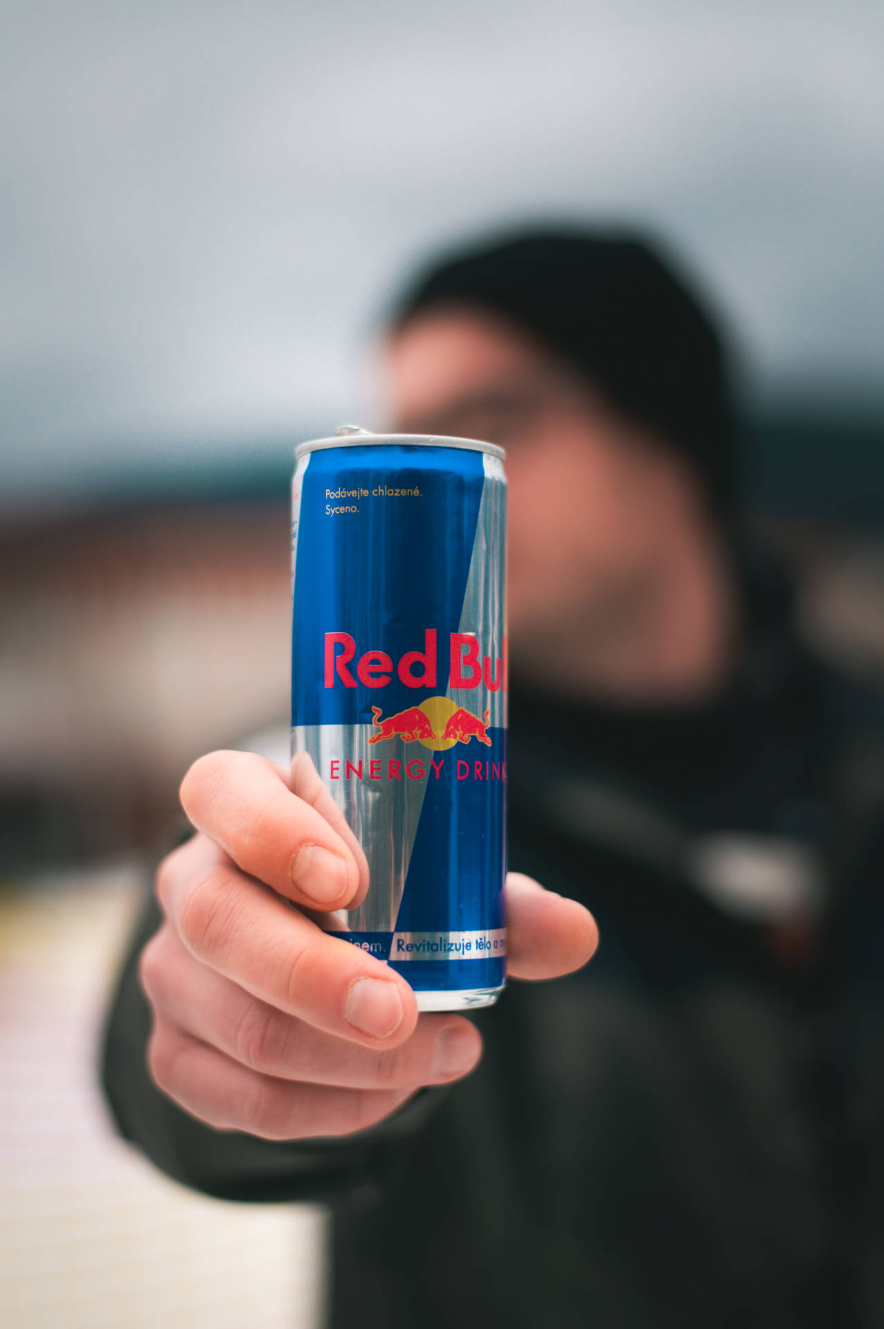 Man Holding Red Bull Can Background
