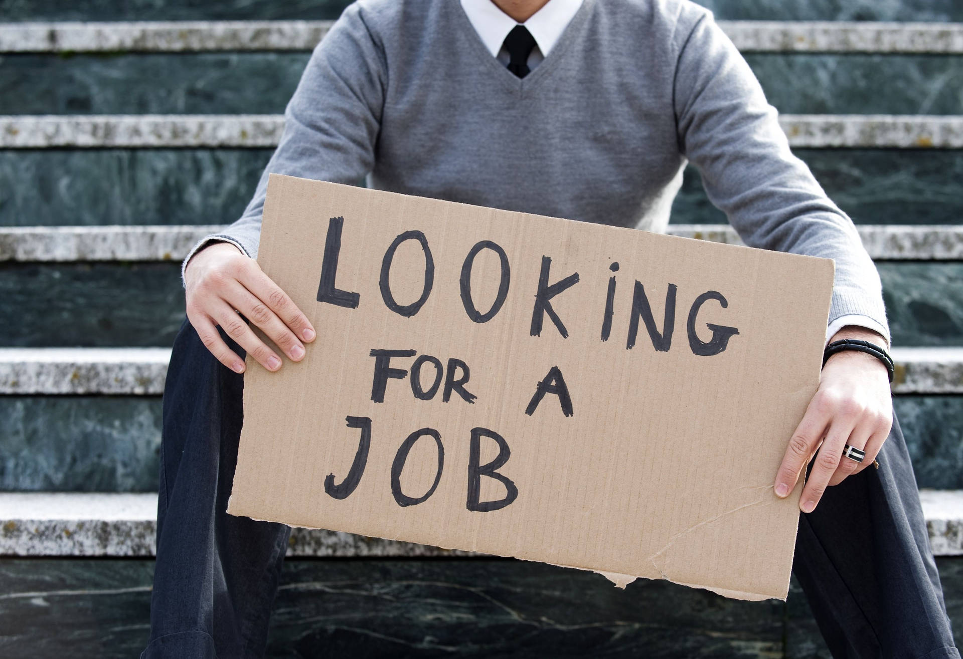 Man Holding Signage Related To Unemployment Background