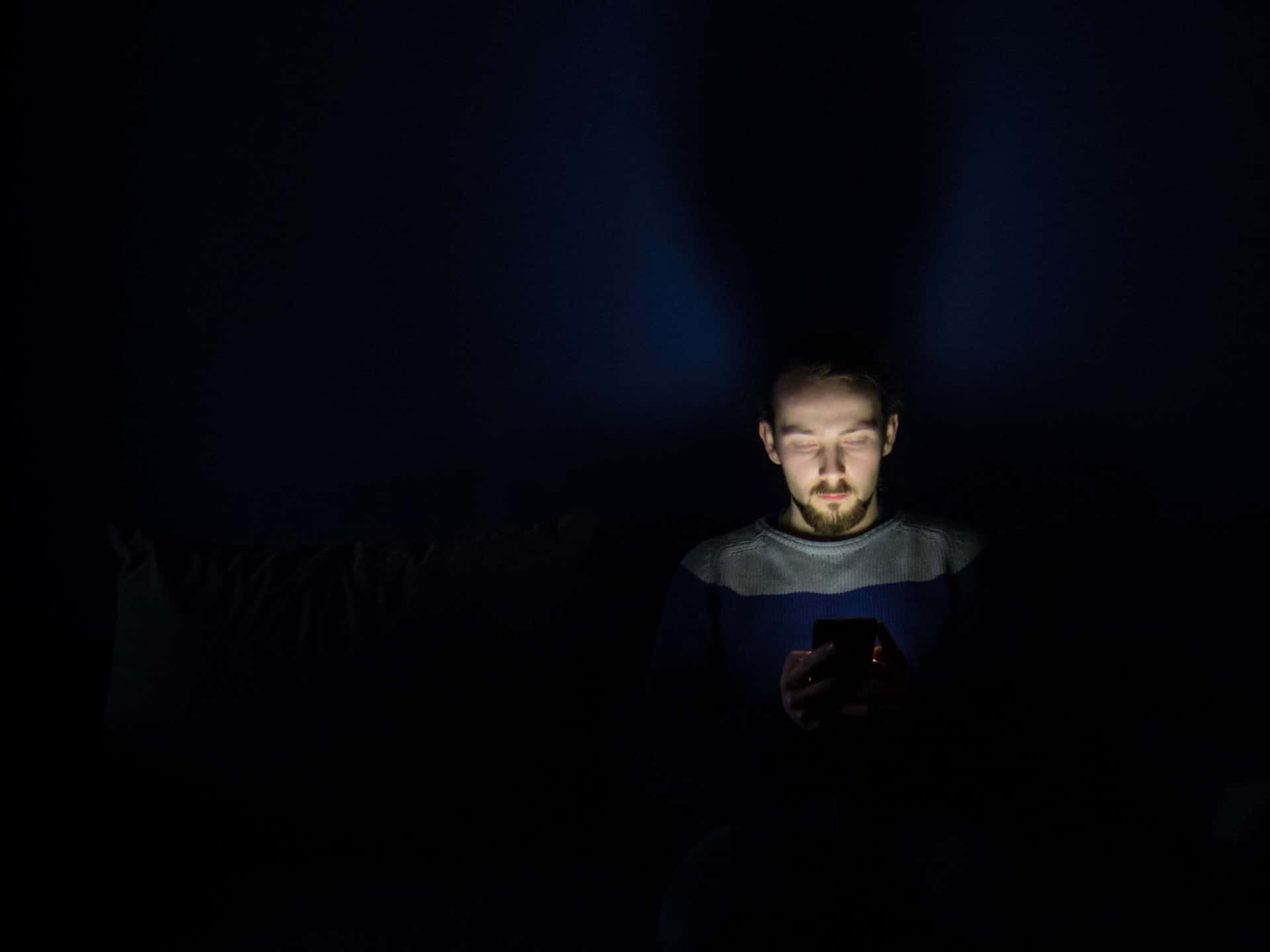 Man In Dark Room With Smartphone Addiction Background