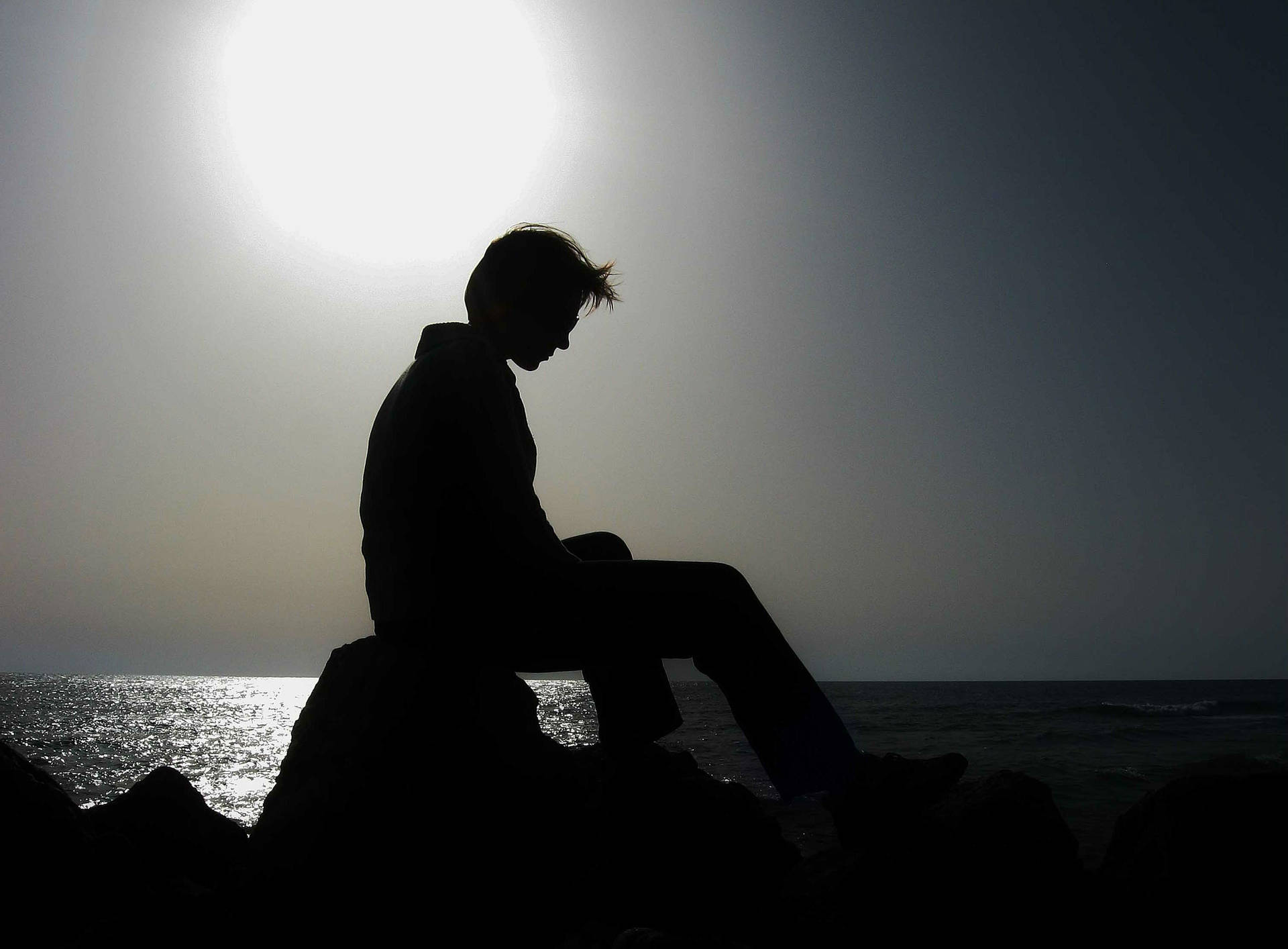 Man In Despair: A Silhouette Of Loneliness Background