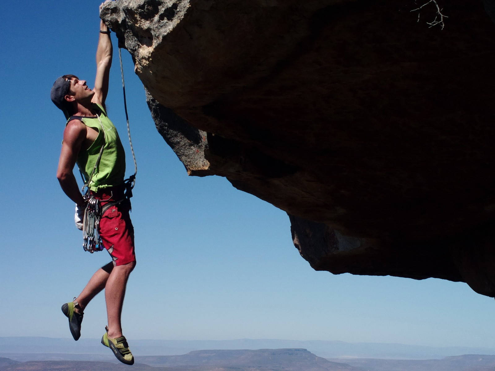 Man In One Hand Rock Climbing