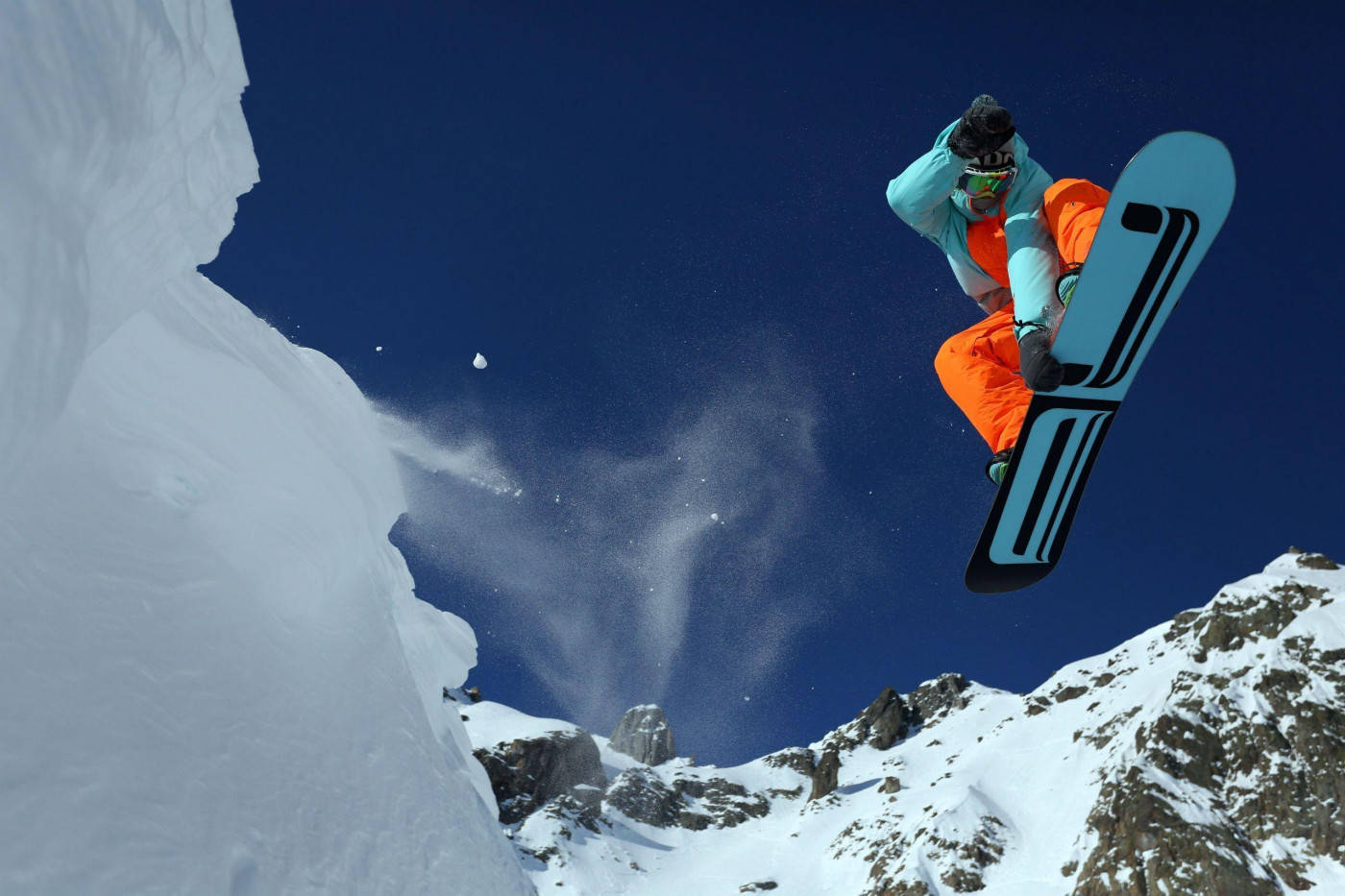 Man In Orange Descending With A Snowboard