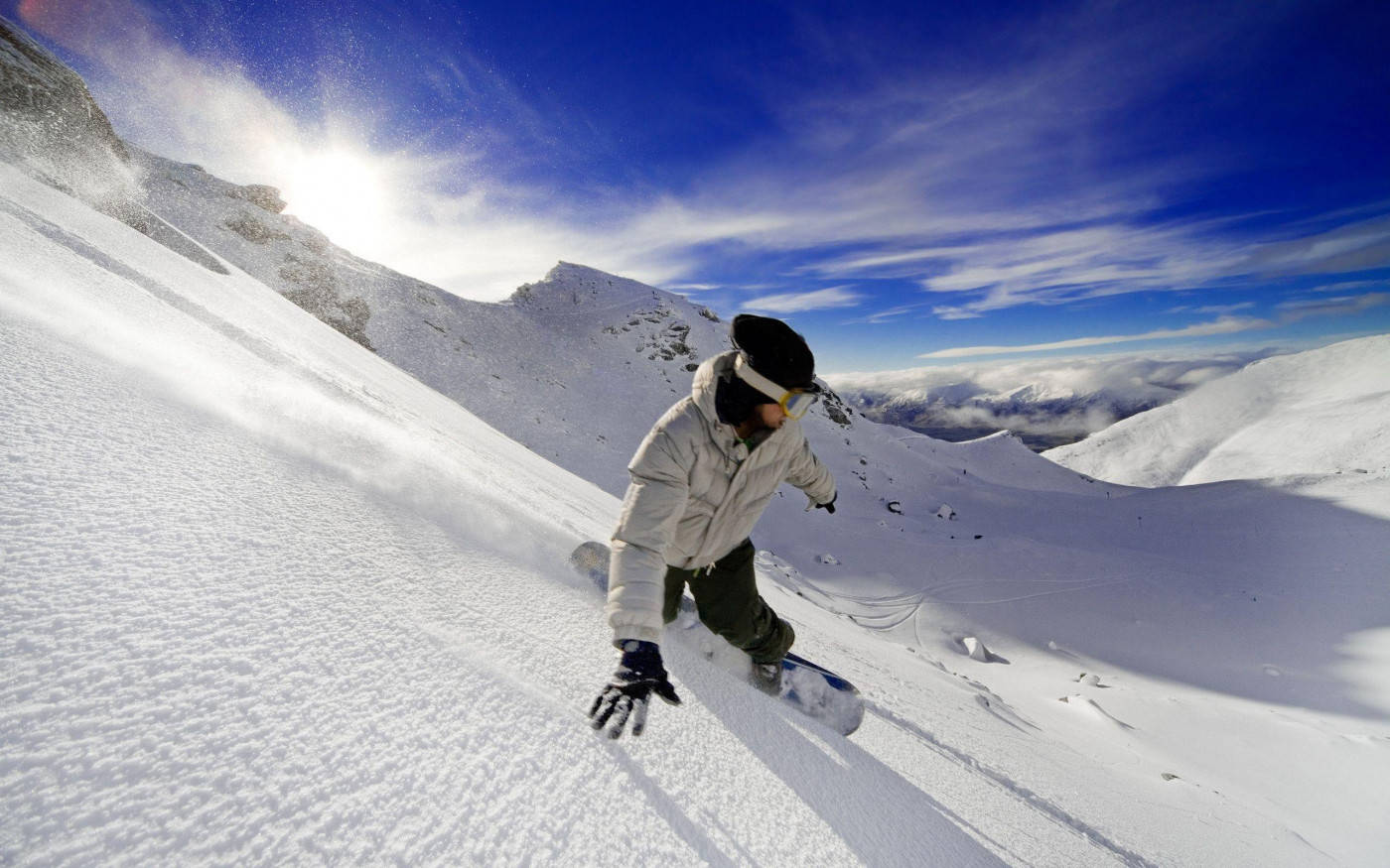 Man In White With Snowboard Descending A Slope