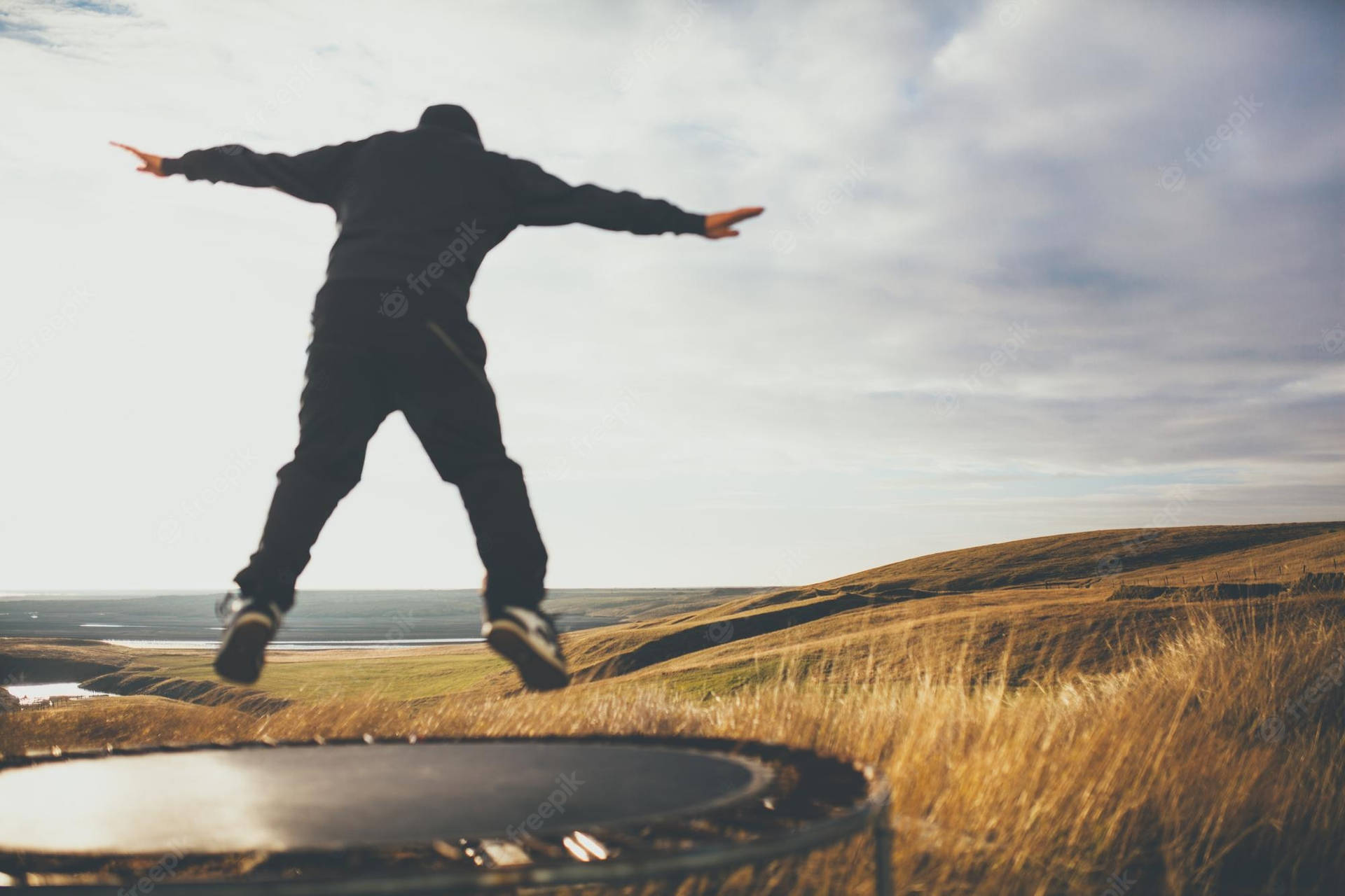 Man Jumping In Trampoline With View