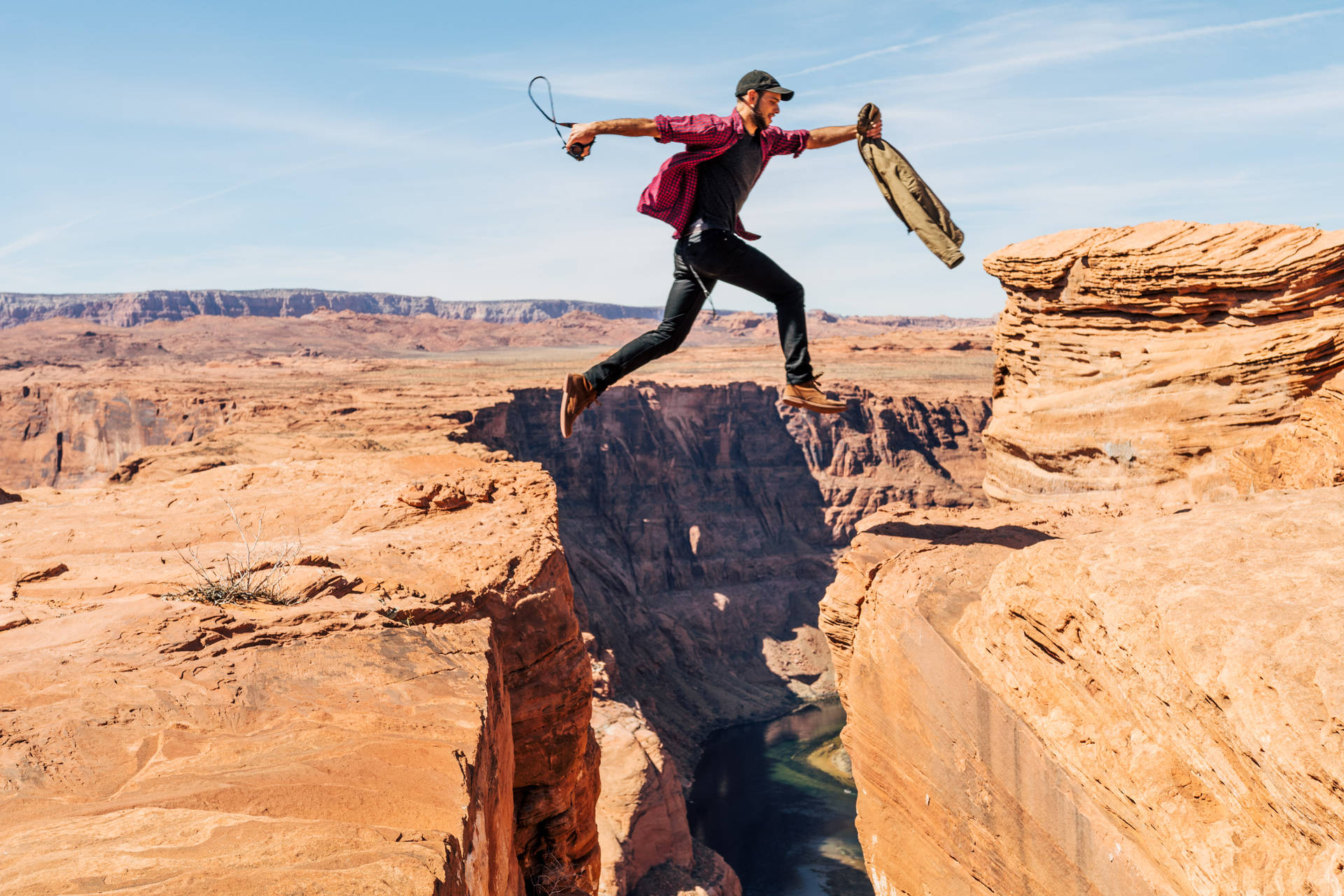 Man Jumping On Rock Formation Background