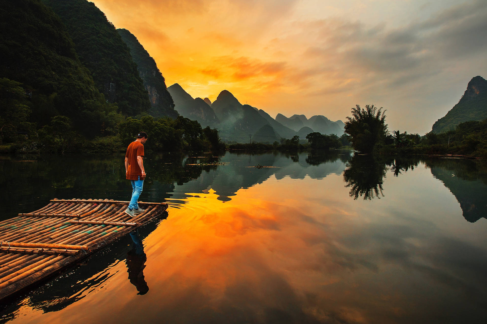 Man On A Raft By The Riverside Background