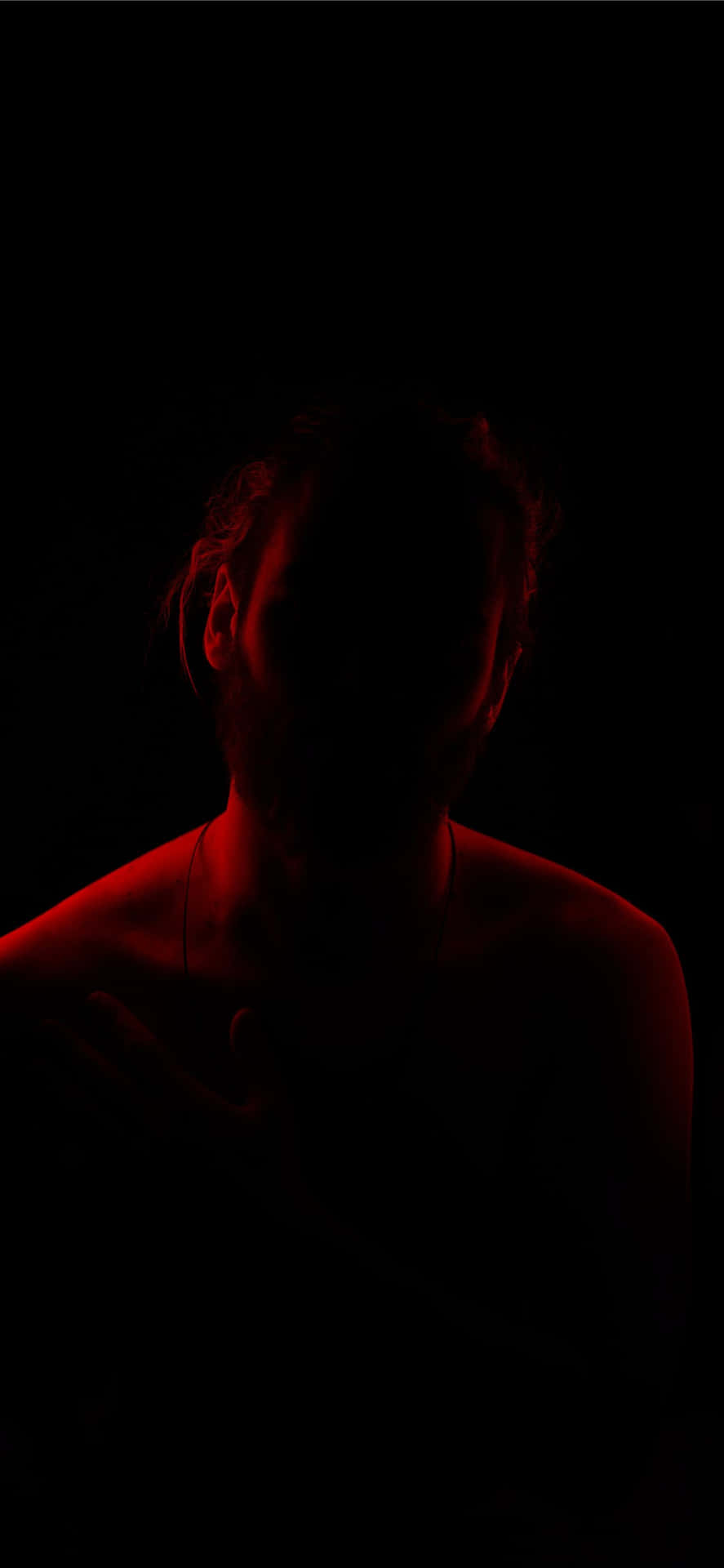 Man On A Somber Night With Red Light Background