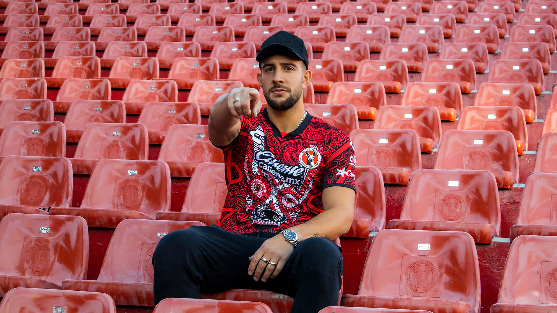 Man Pointingin Stadium Seats Background