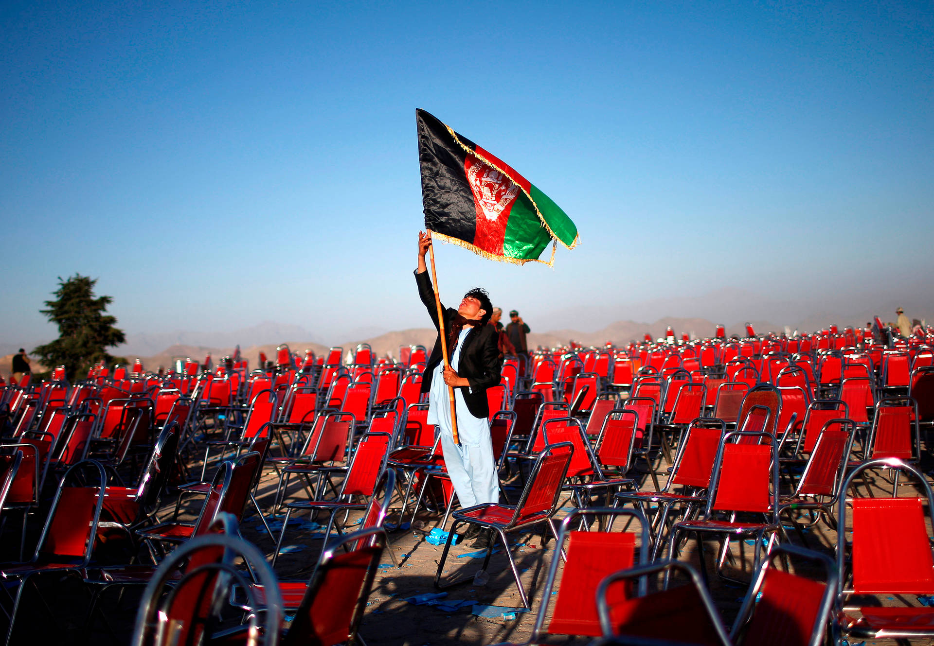 Man Raising Afghanistan Flag Background