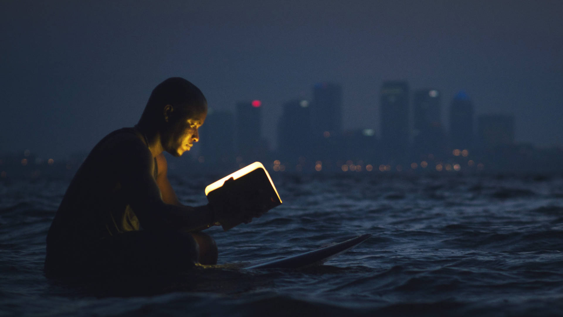 Man Reading Book In Ocean Background