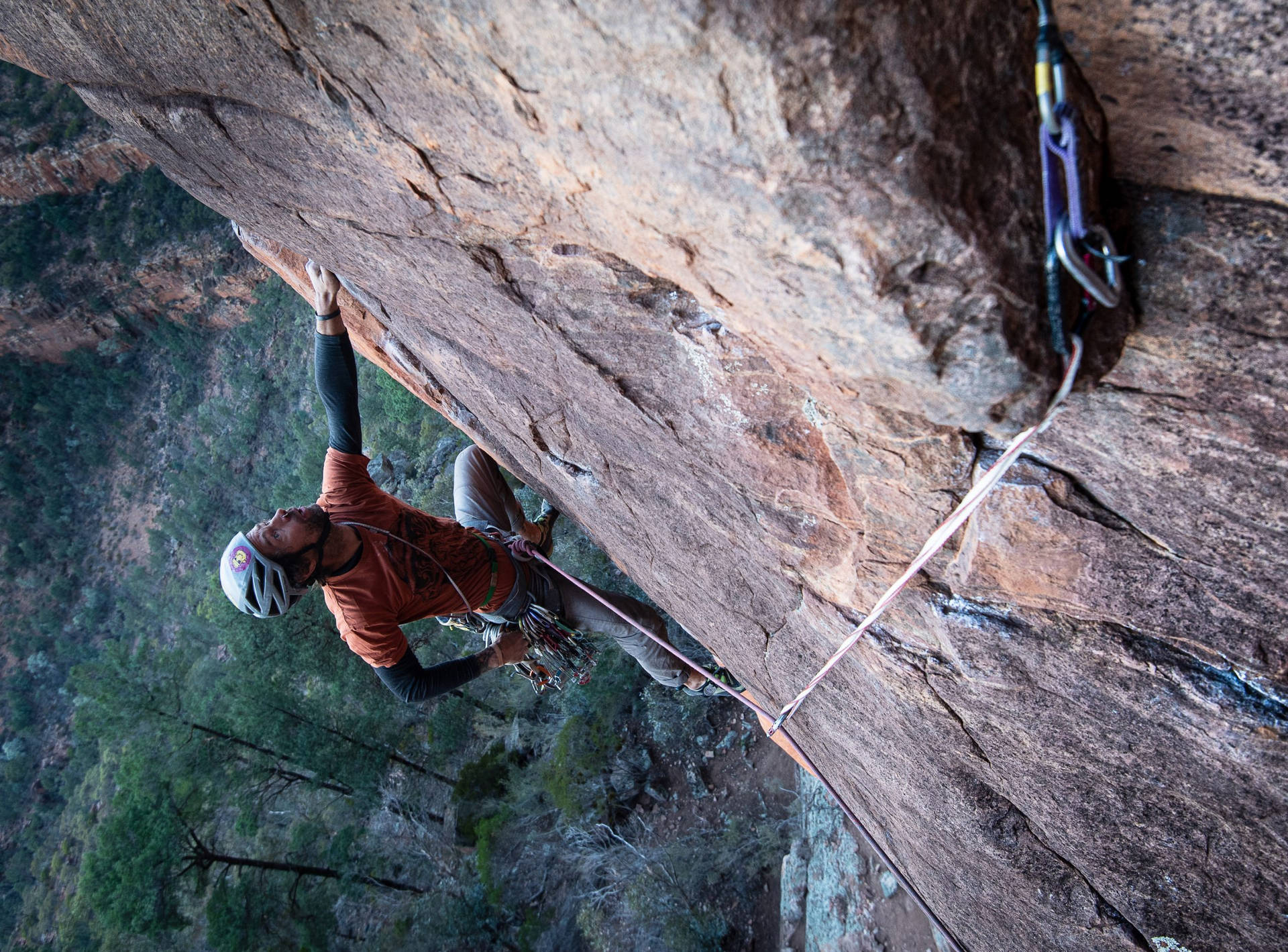 Man Rock Climbing On A Flip Rock Structure Background