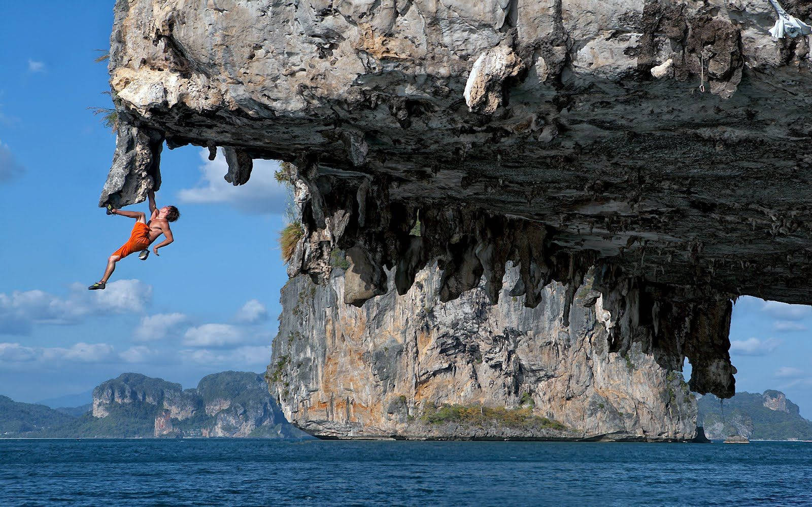 Man Rock Climbing Over The Sea Background