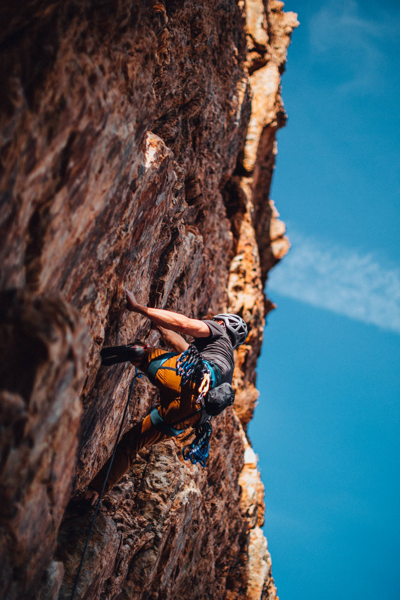 Man Rock Climbing Under A Blue Sky