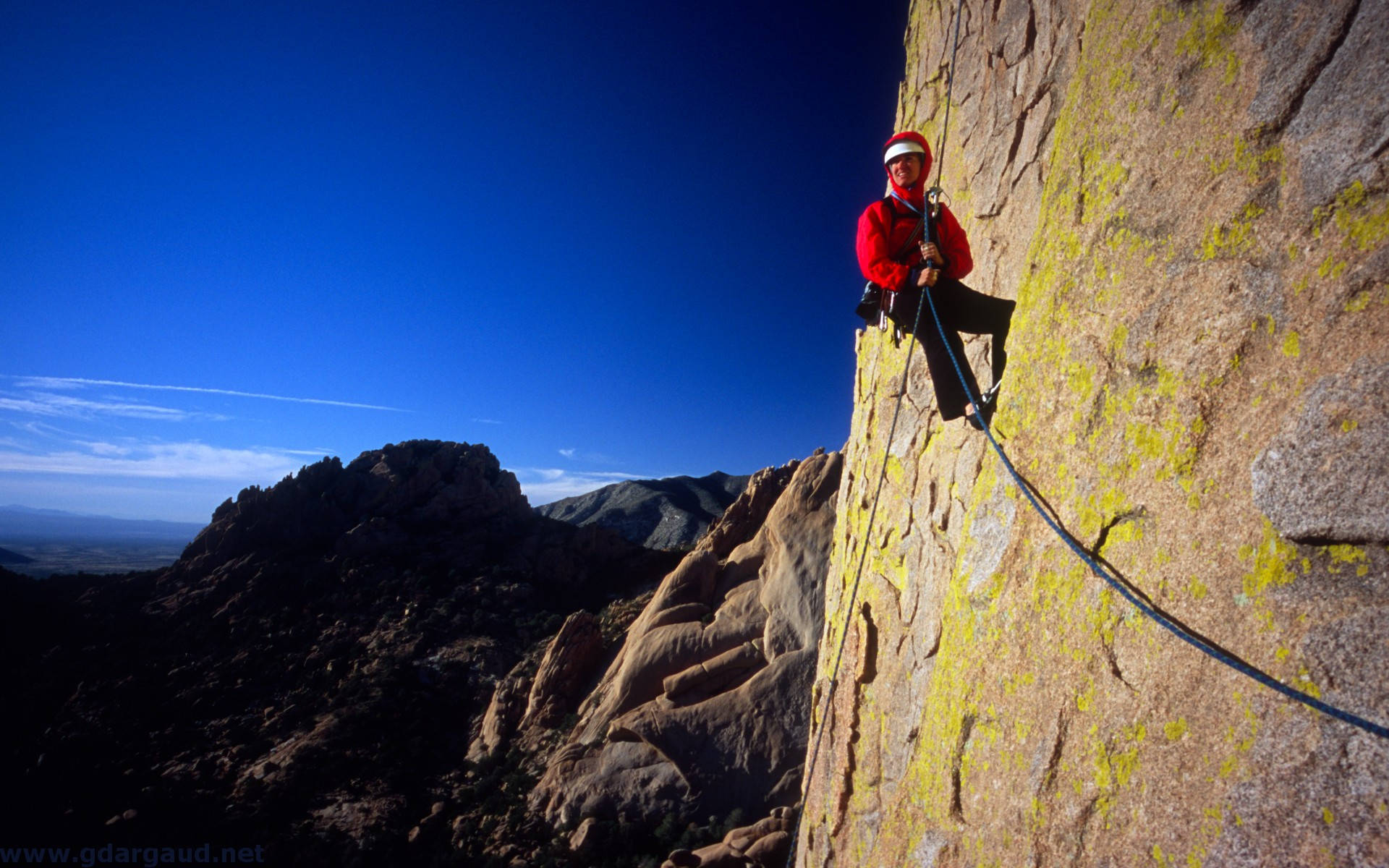 Man Rock Climbing While Holding A Rope Background