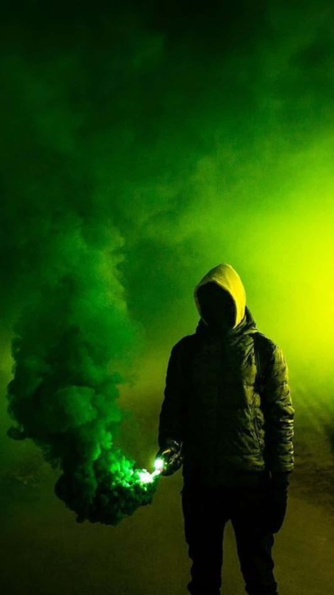 Man Silhouetted Against Green Smoke Explosion Background