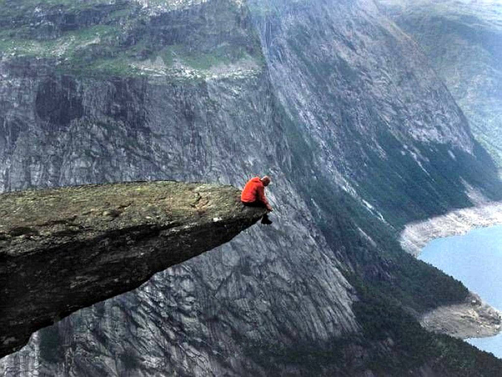 Man Sitting Alone At Cliff Edge