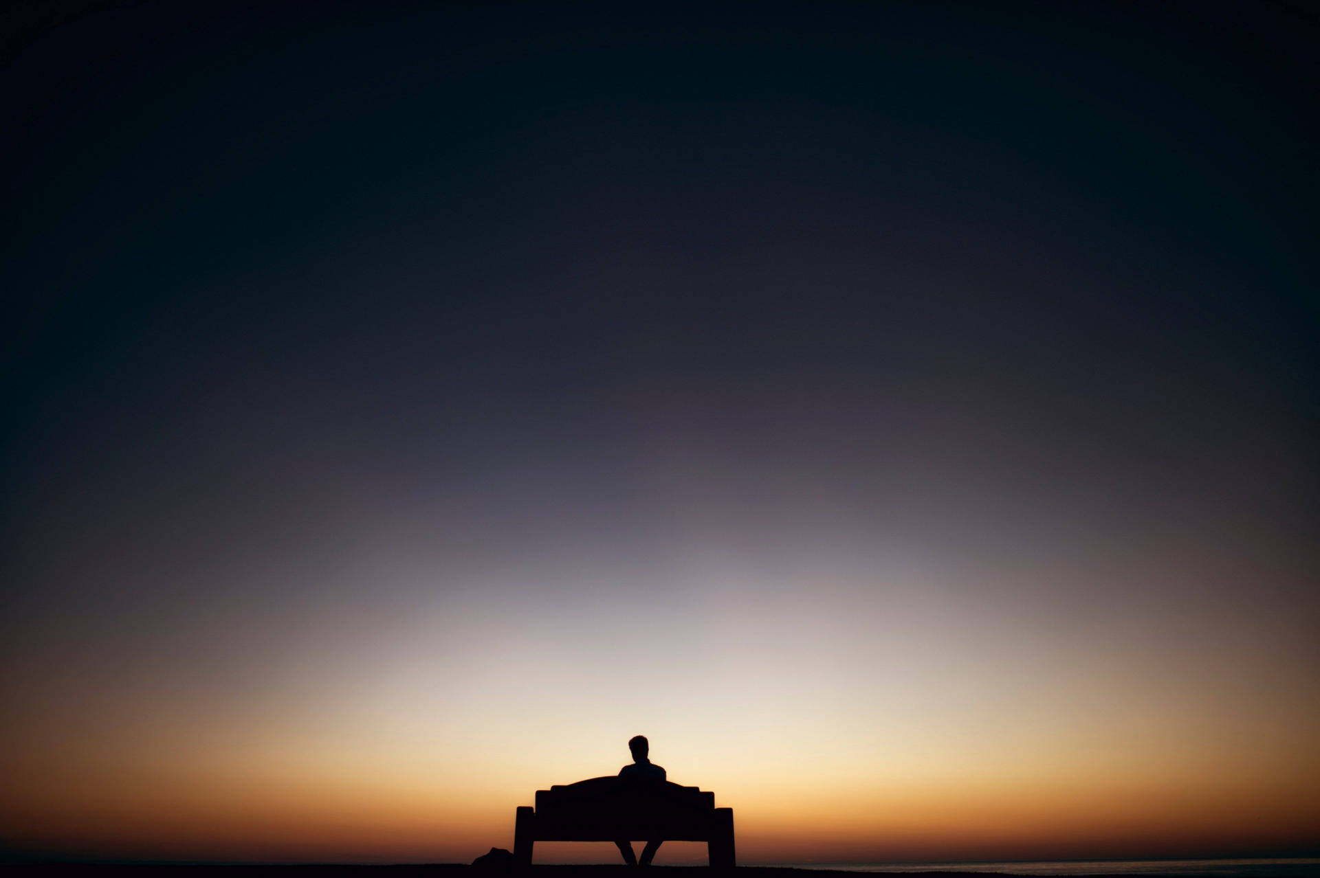 Man Sitting Alone Under Gradient Sky Background