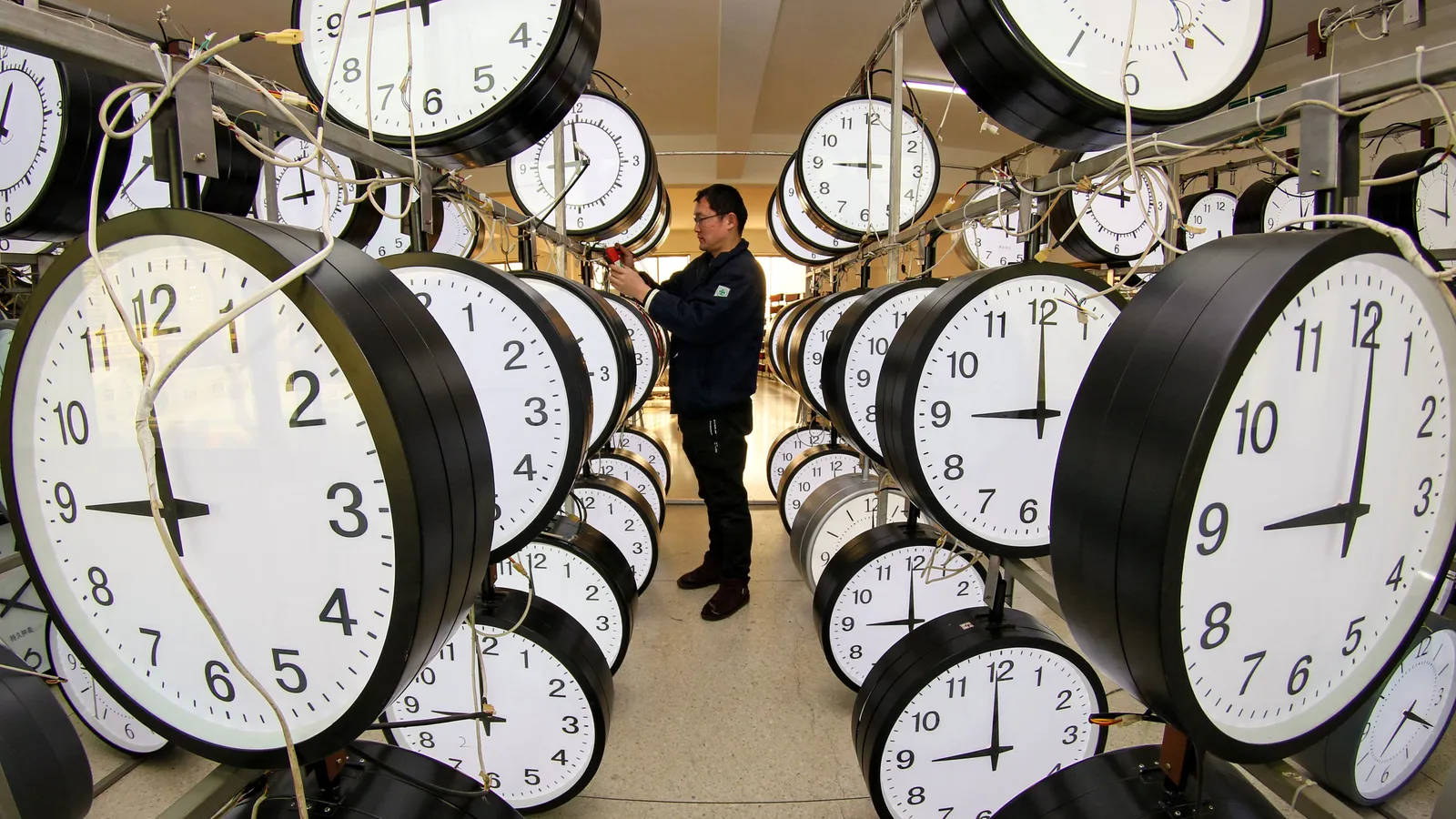 Man Synchronizing Various Clocks Background