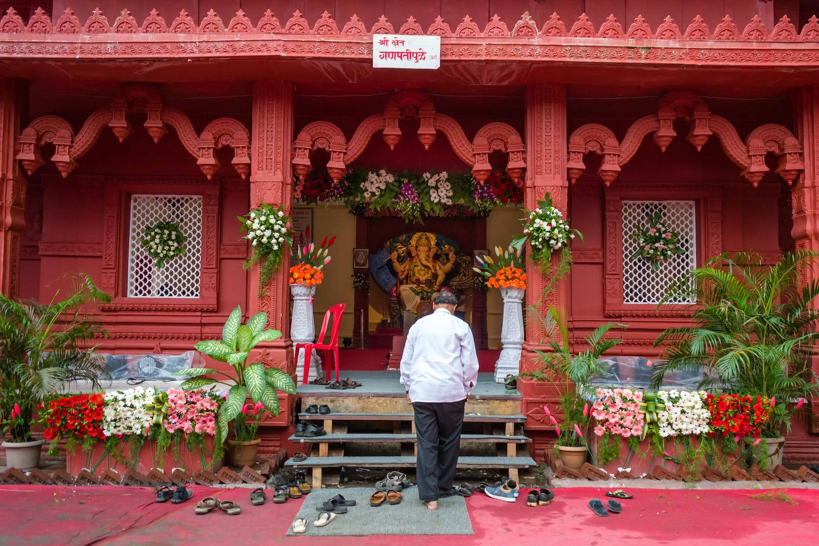 Man Visiting A Vinayaka Shrine Background
