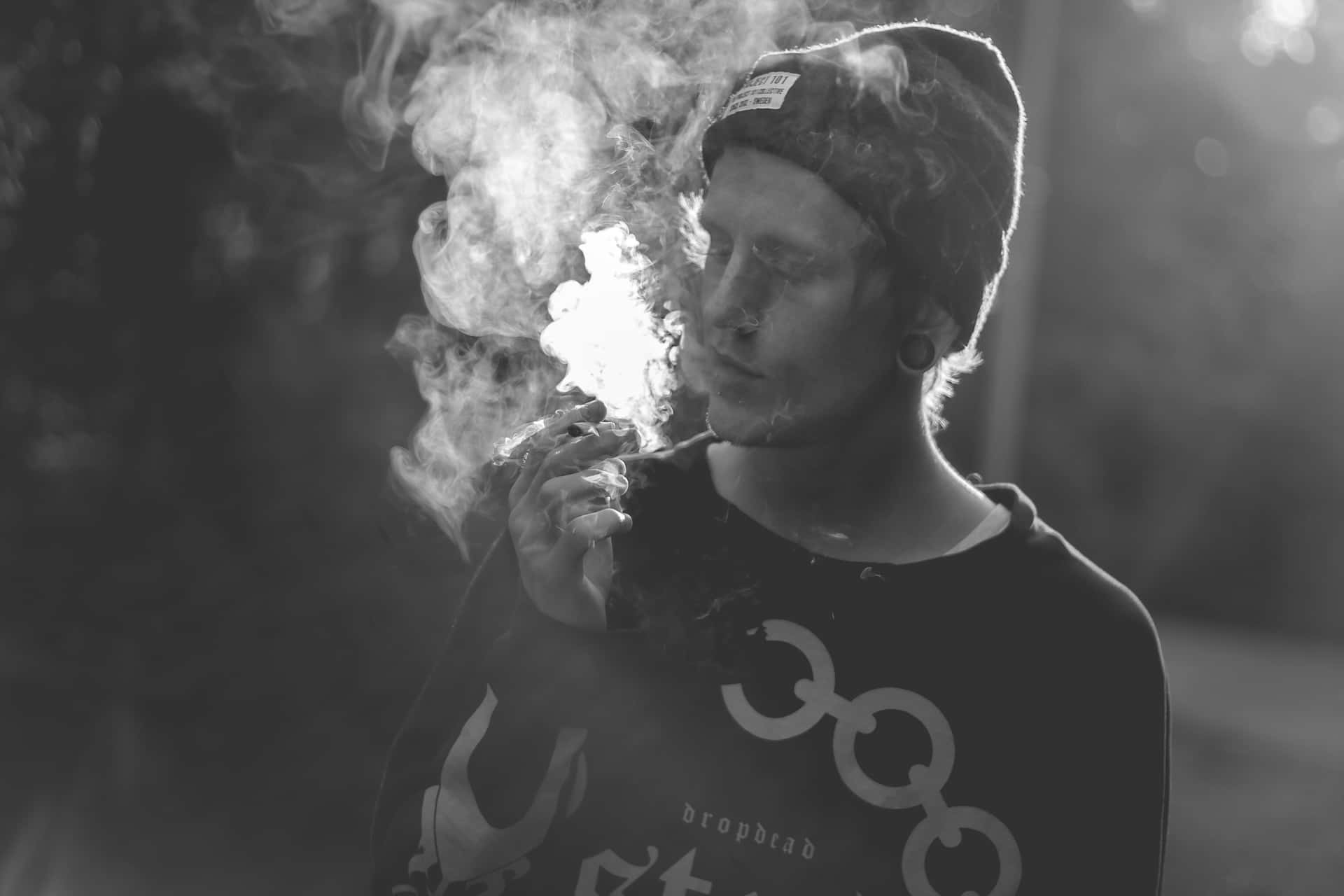 Man With Bonnet Smoking A Joint Background