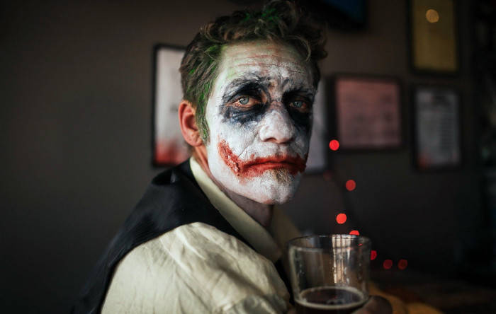 Man With Drink And Sad Joker Makeup Background