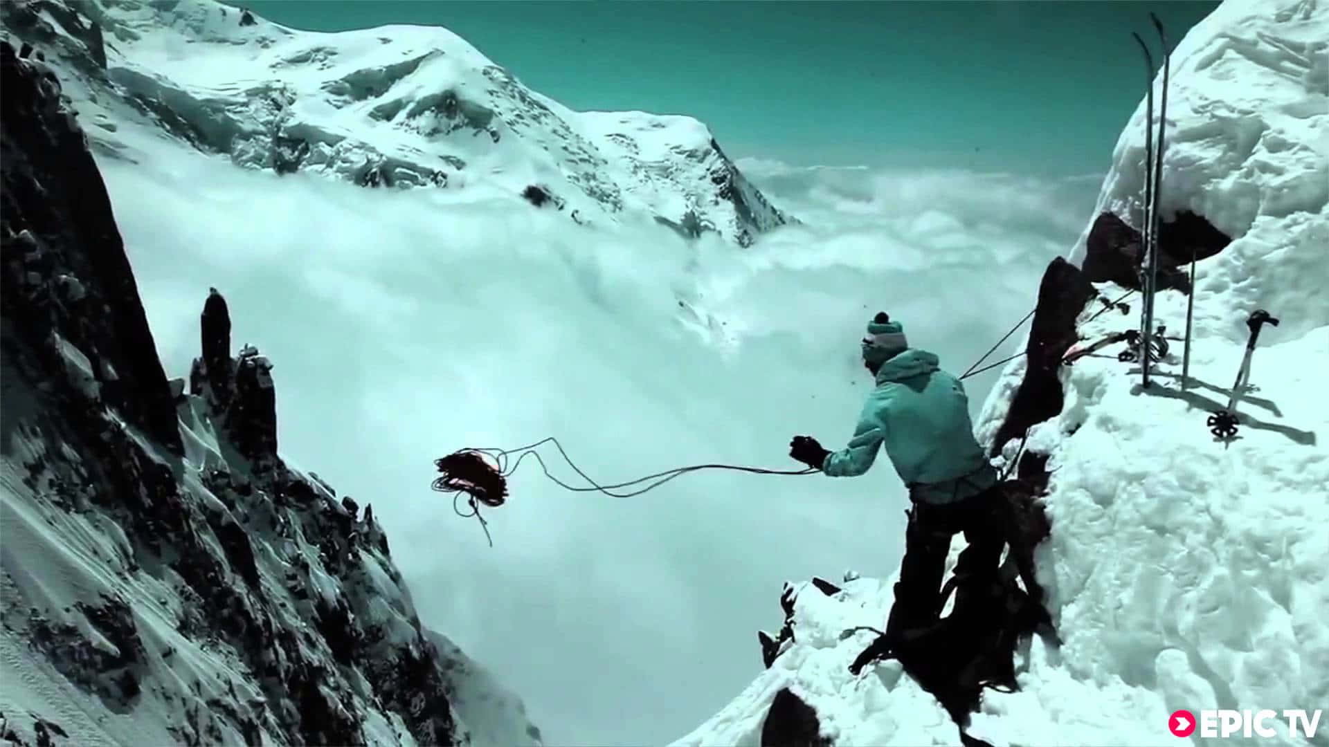 Man With Long Rope Of Steep Mountain Background