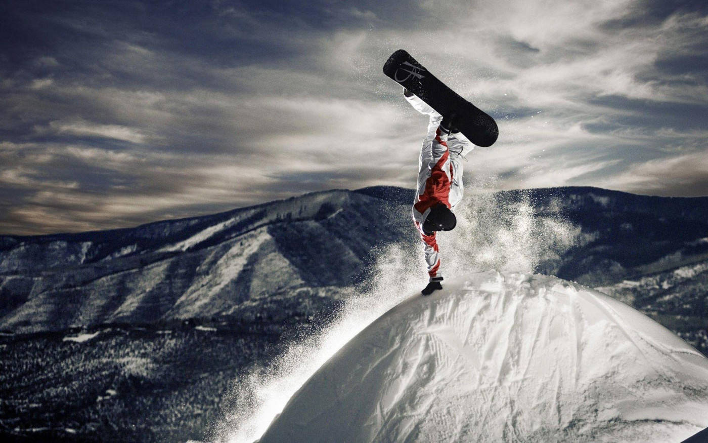 Man With Snowboard Leaping Over Mountain Background