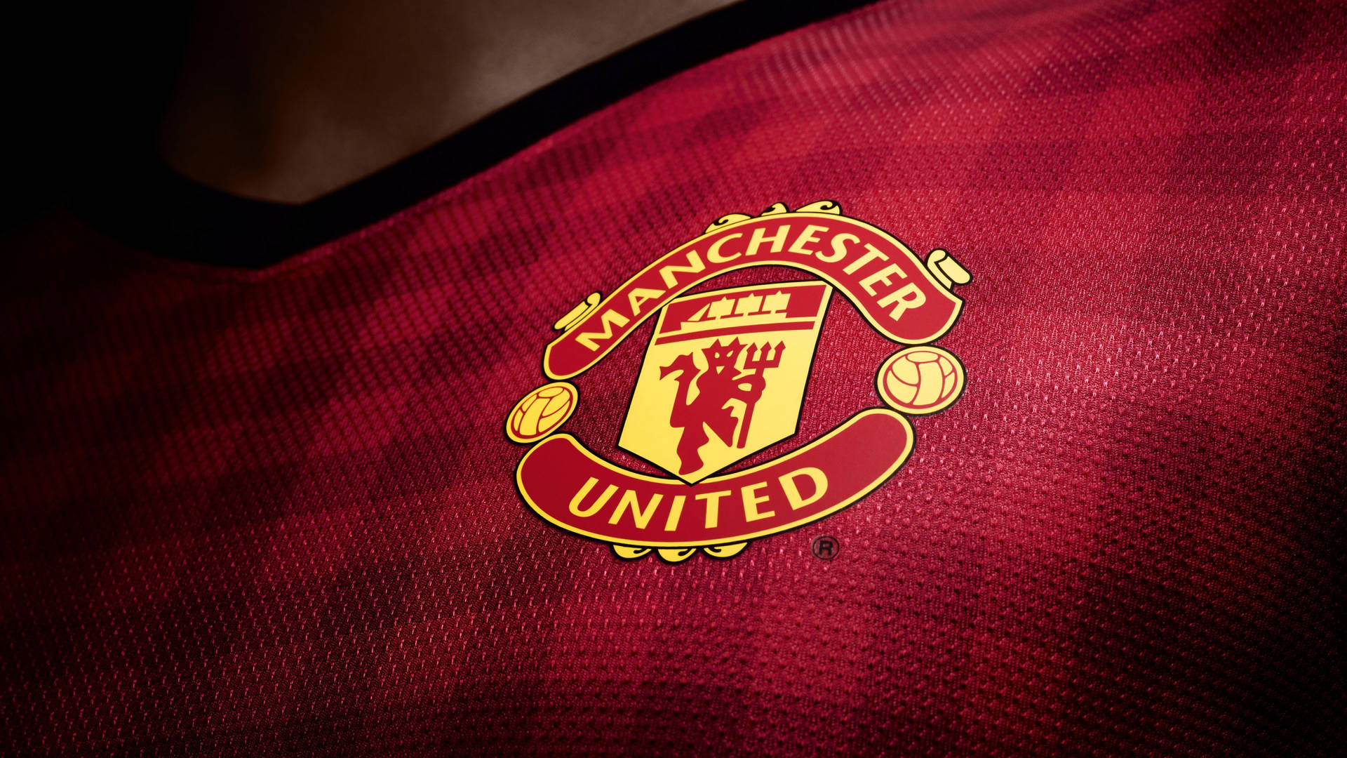 Manchester United Logo On Red Jersey Background