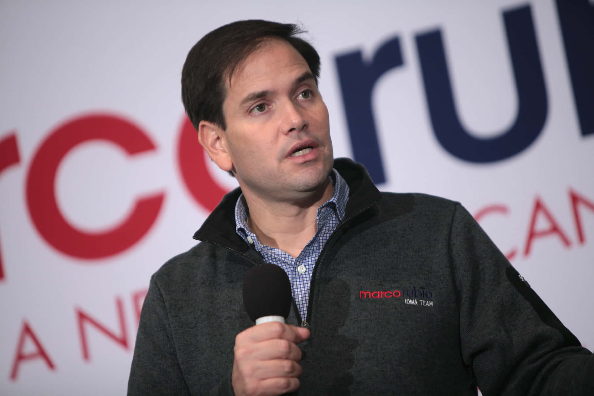 Marco Rubio Holding A Microphone Background