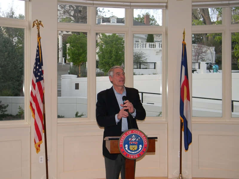 Mark Udall At Podium Background