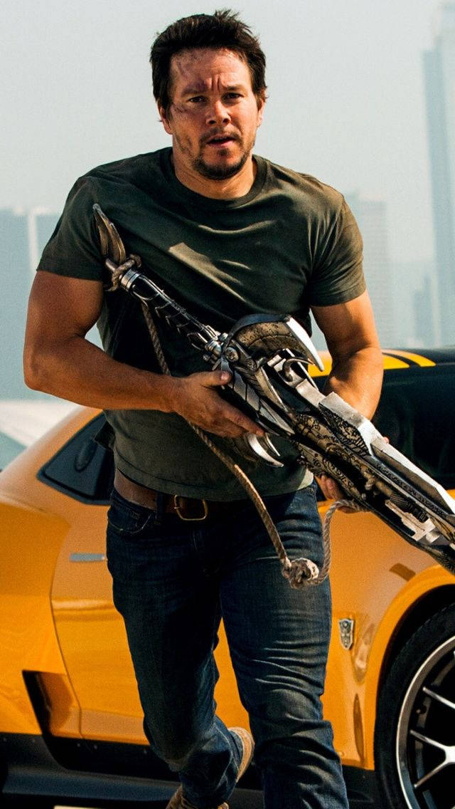 Mark Wahlberg Holding A Weapon Background