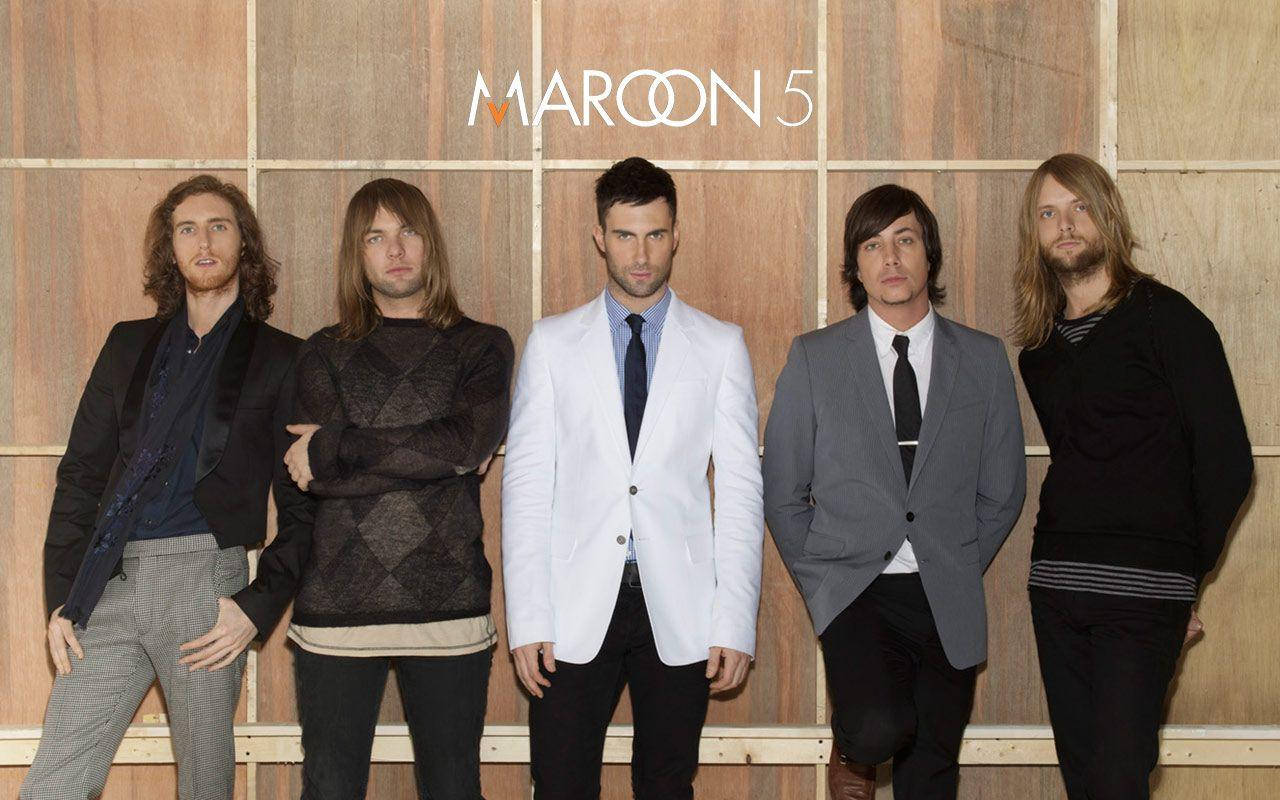 Maroon 5 Band Posing On A Wooden Background Background