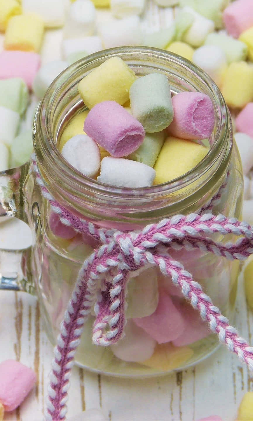 Marshmallows In A Jar On A Wooden Table Background