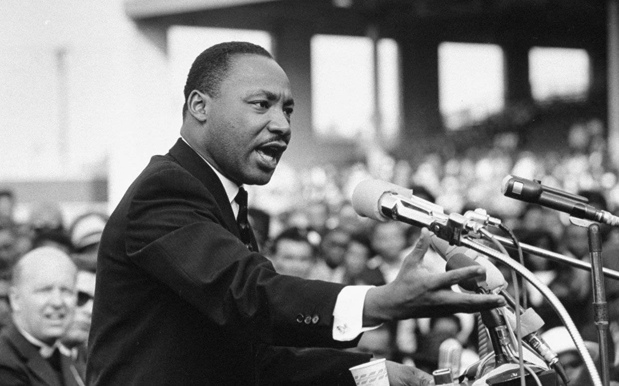 Martin Luther King Jr Speaking In Front Of Crowd Background