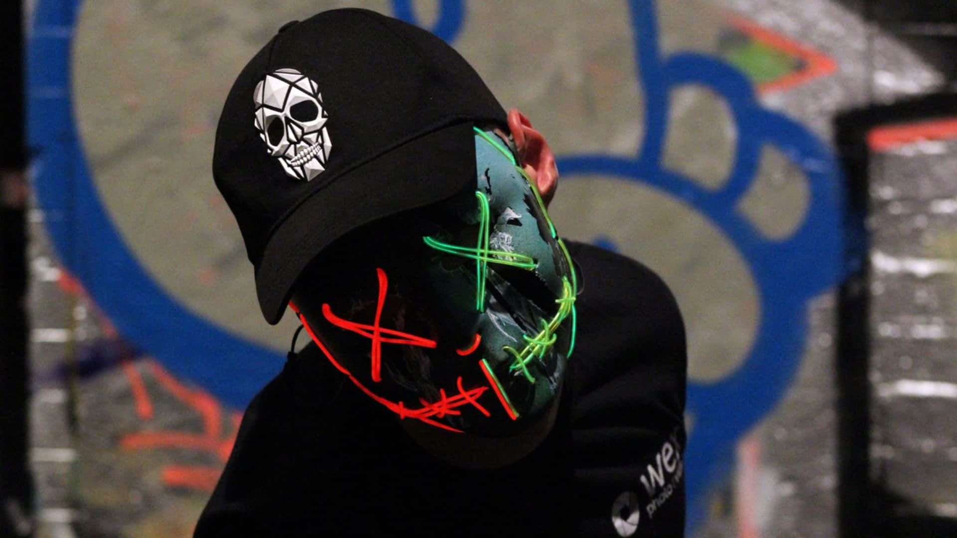Masked Man With A Black Cap With Skull Logo Background