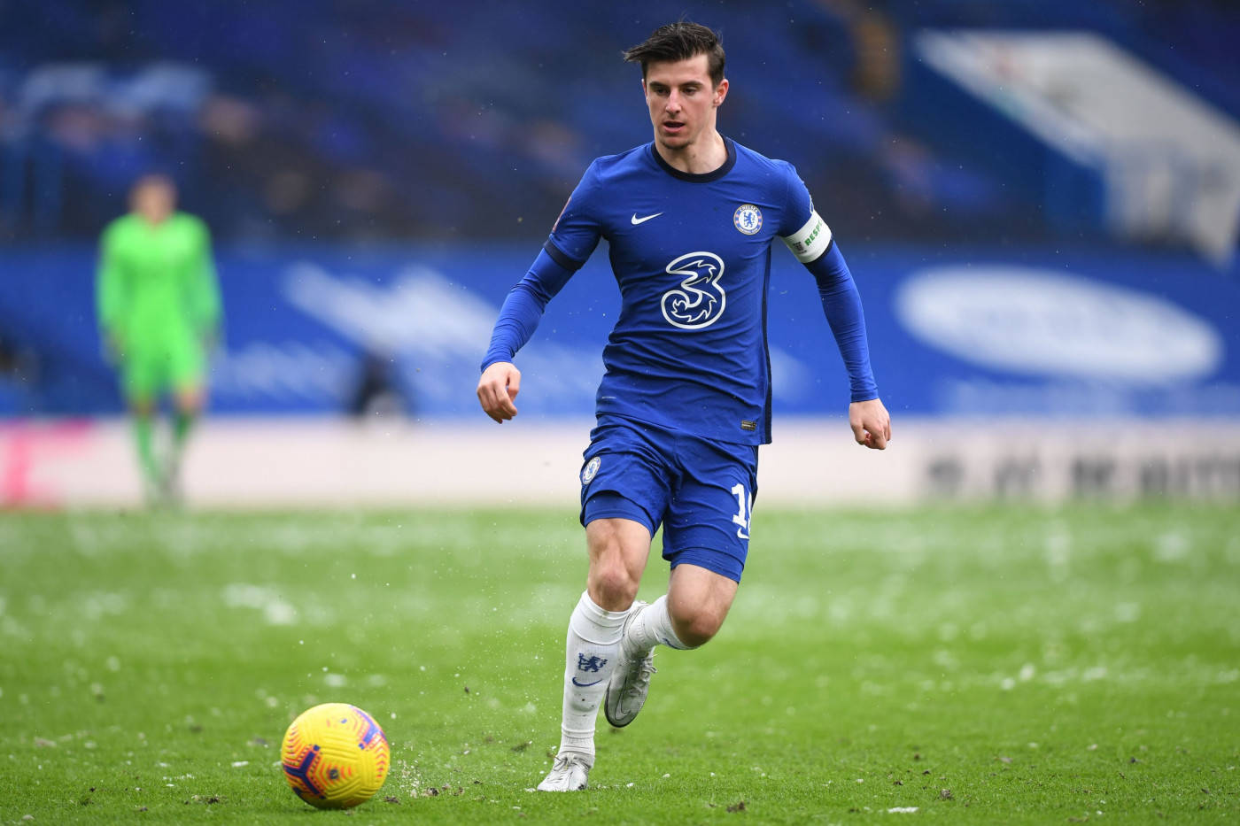 Mason Mount In Blue Kicks Yellow Football Background