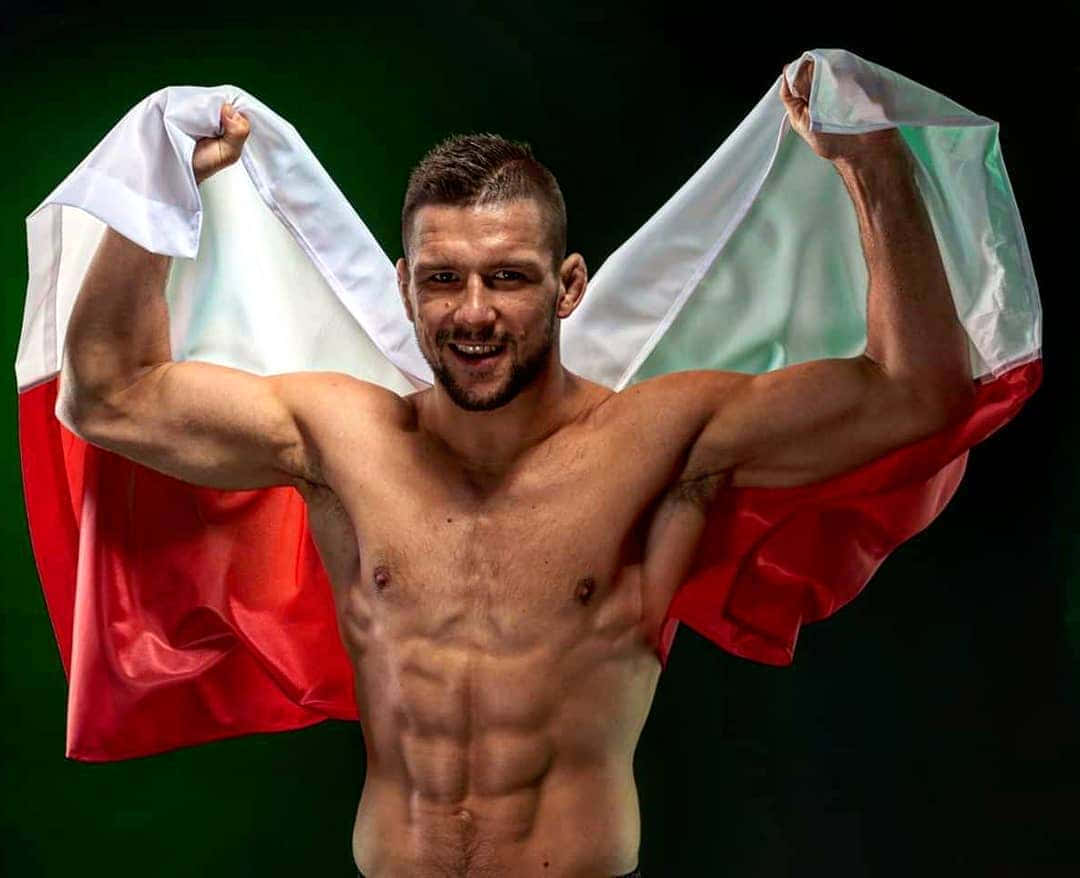 Mateusz Gamrot Showing Off Muscles Background