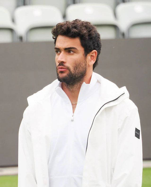 Matteo Berrettini In White Jacket Background