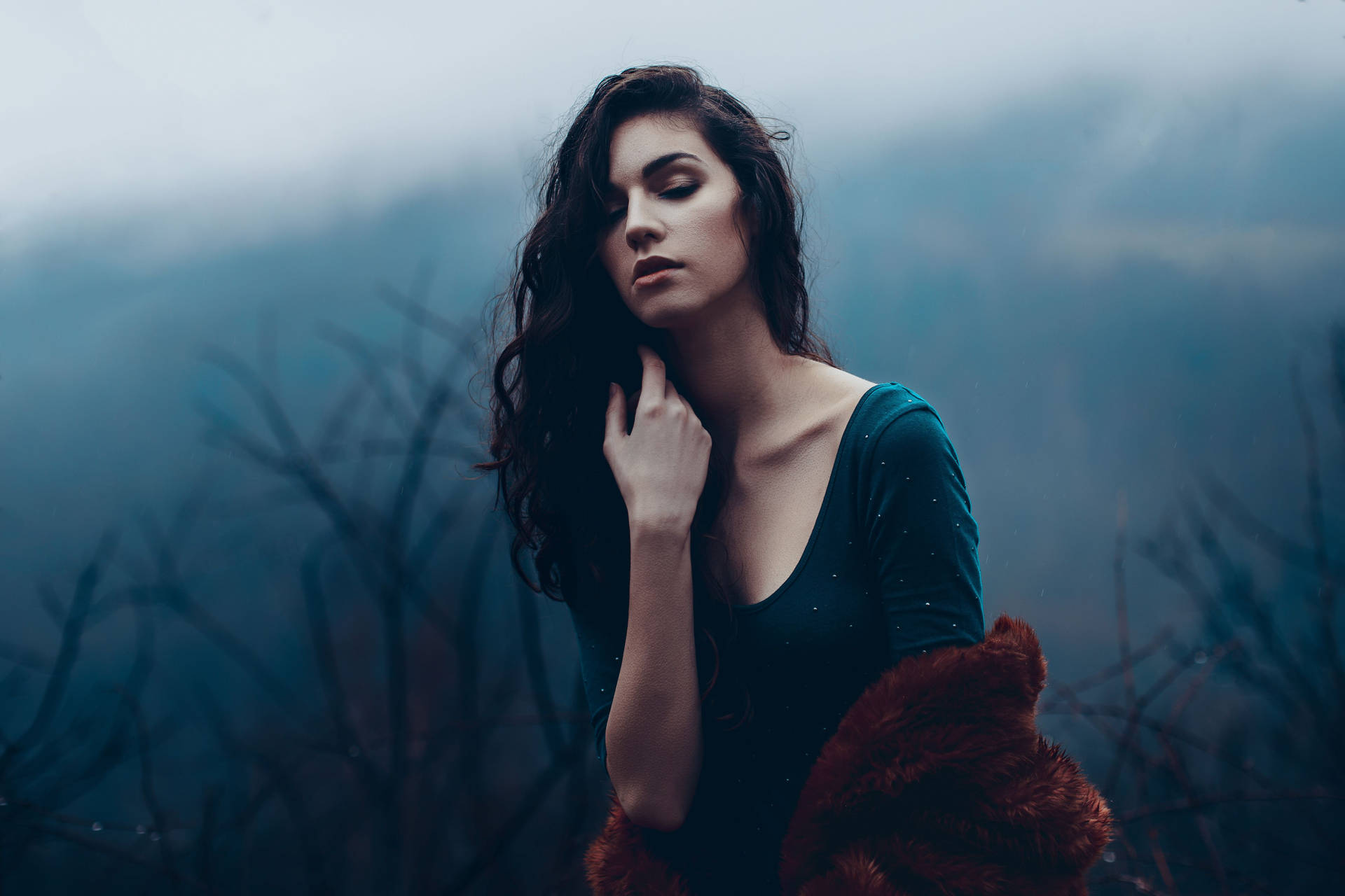 Mature Woman Posing By A Dark Forest Background