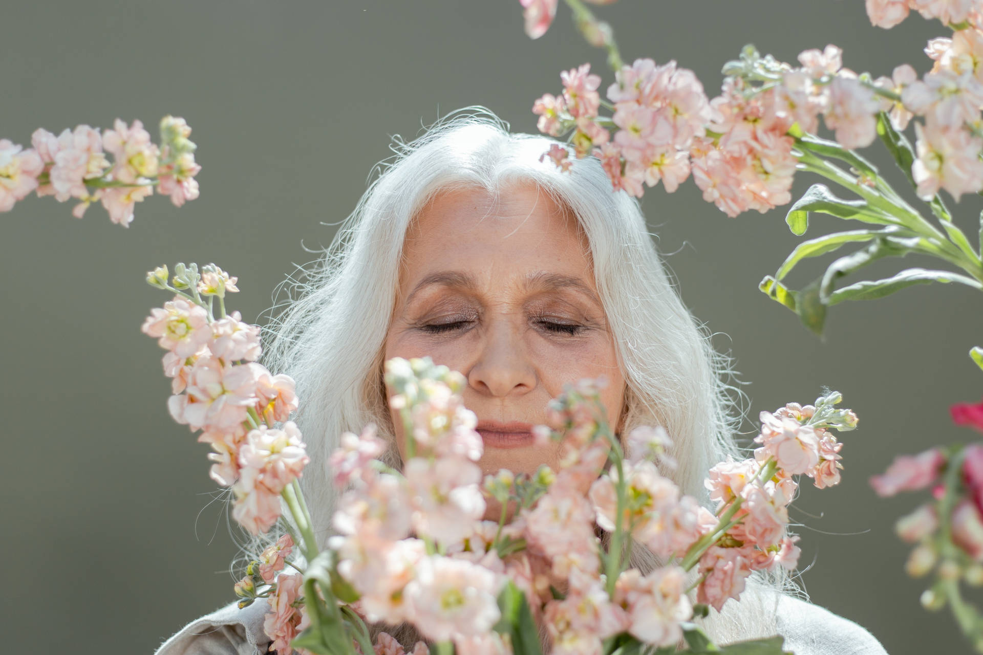 Mature Woman Surrounded By Flowers Background