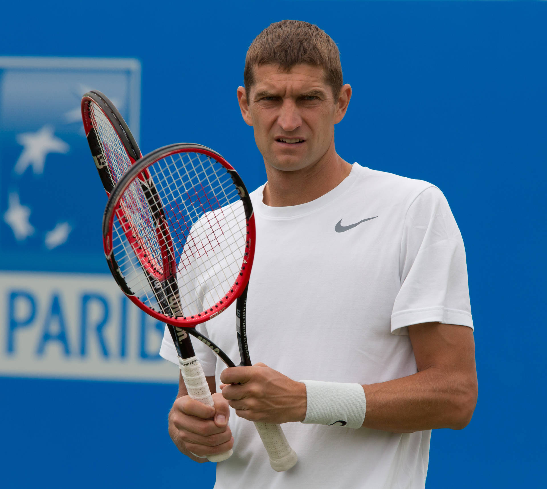 Max Mirnyi Holding Two Tennis Rackets Background