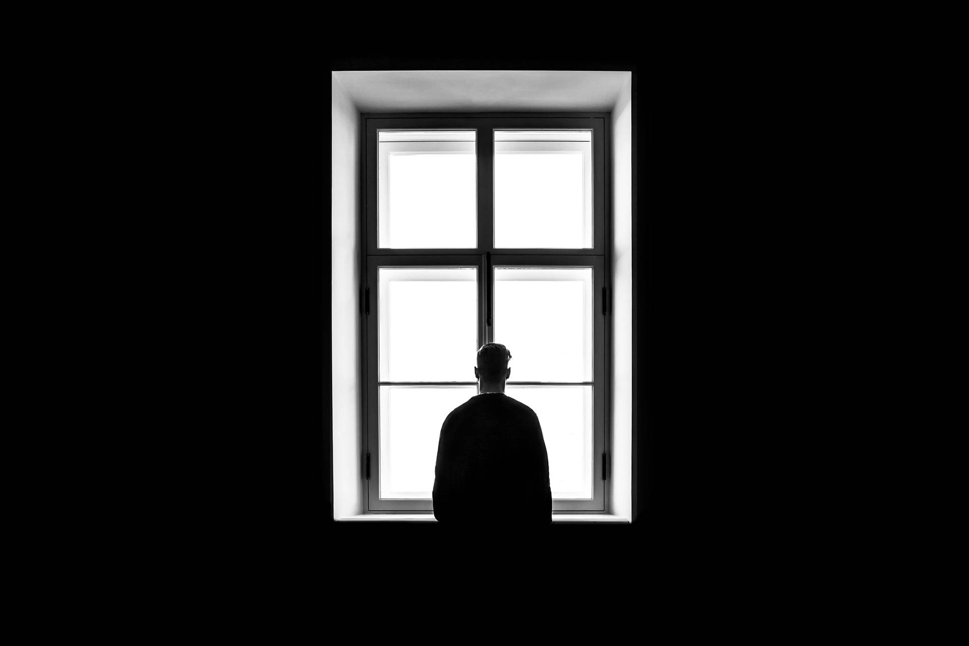 Melancholy Man Gazing Out Of The Window Background