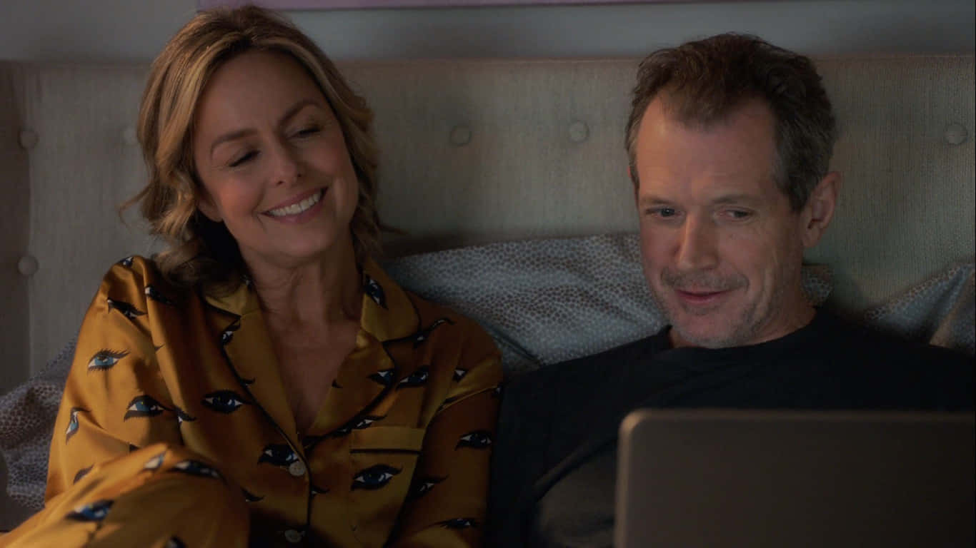 Melora Hardin Smiling Beside Man With Laptop Background