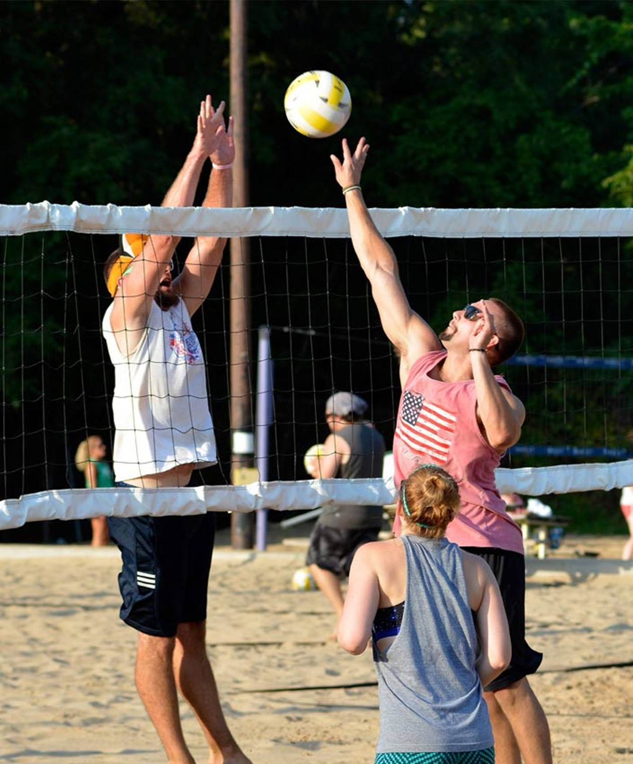 Men And Woman Playing Beach Volleyball Background