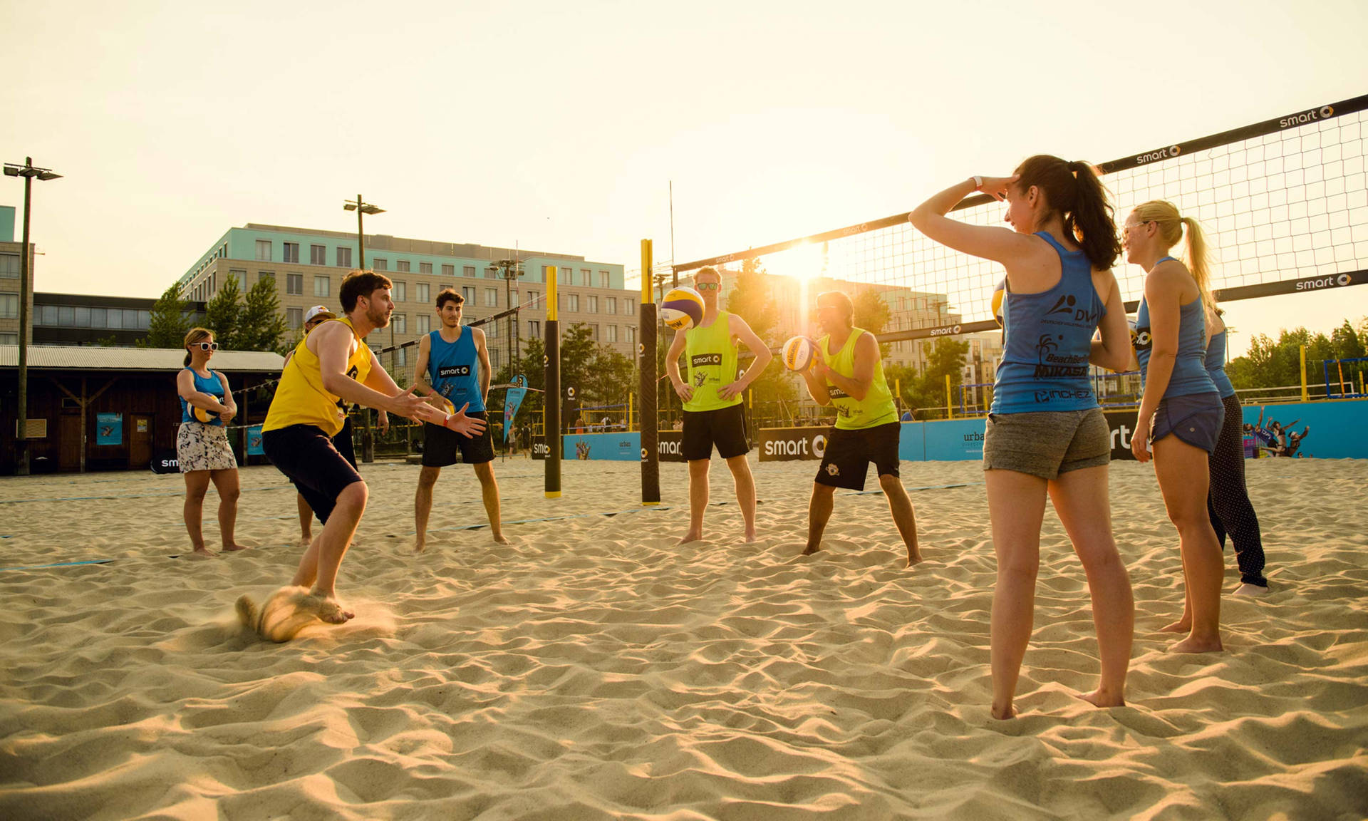 Men And Women Playing Beach Volleyball Background