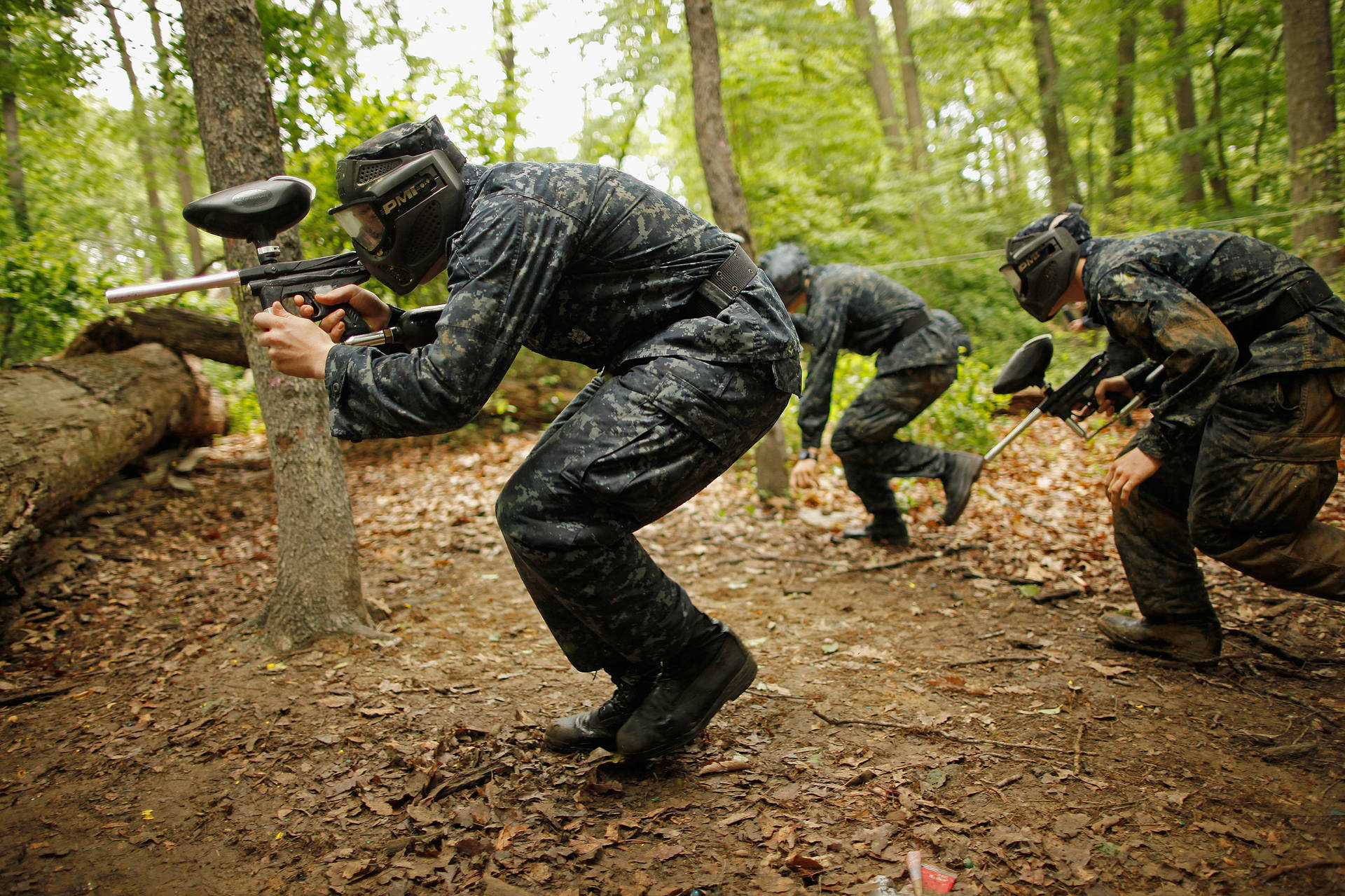 Men In Camouflage Gear Playing Paintball Background