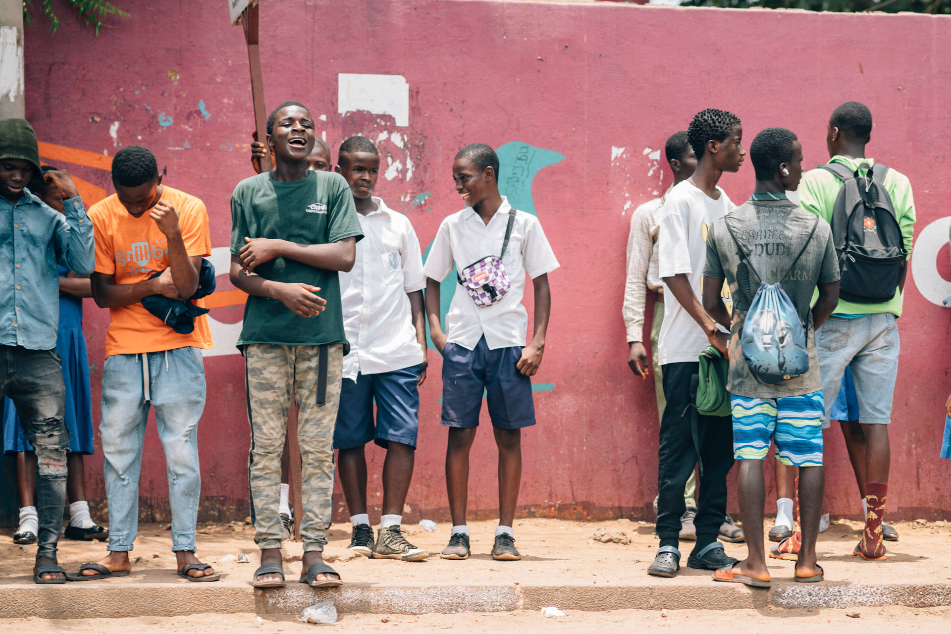 Men In Sierra Leone Waiting By Wall Background