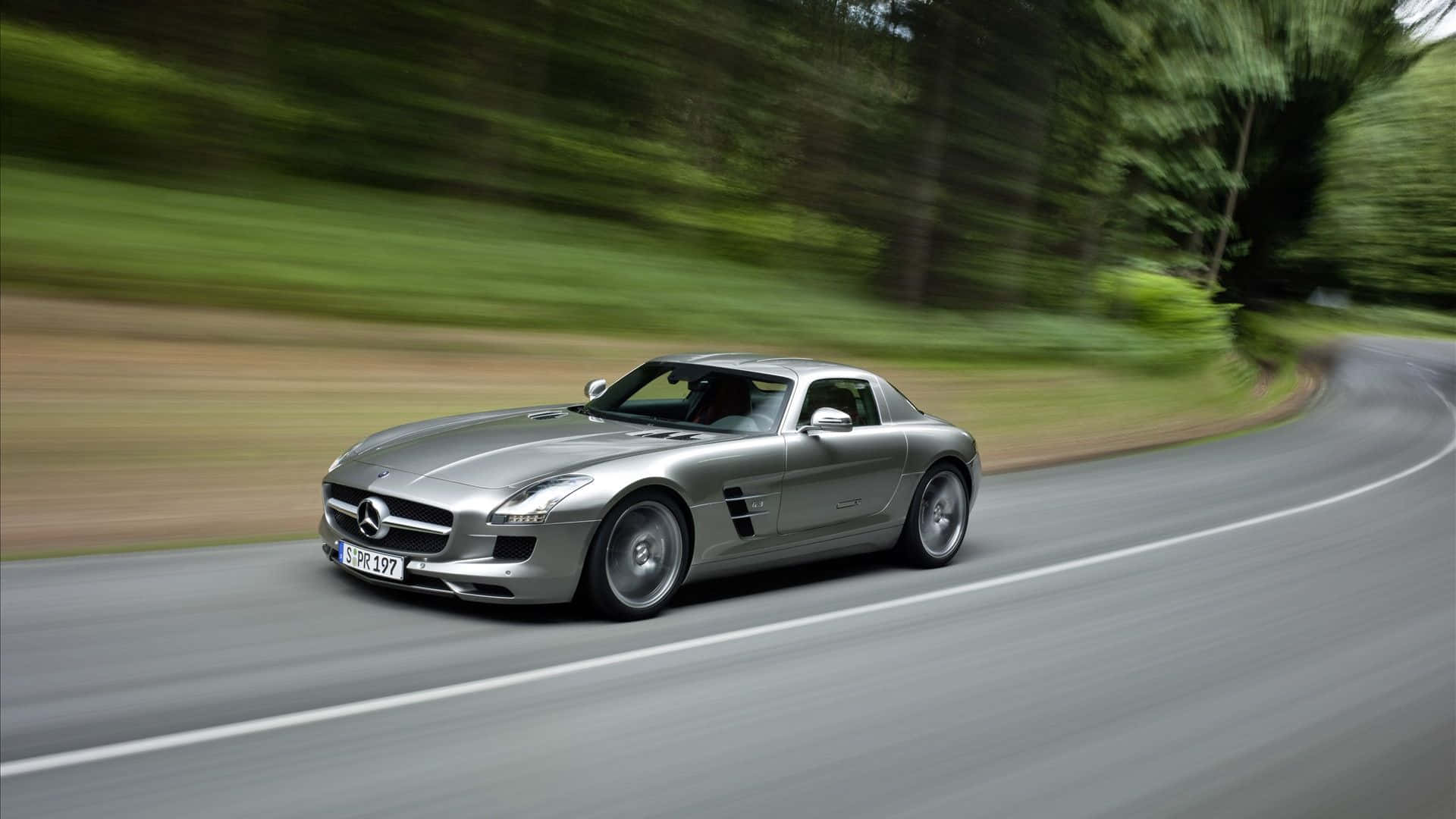 Mercedes Sls Amg Driving Down A Road Background