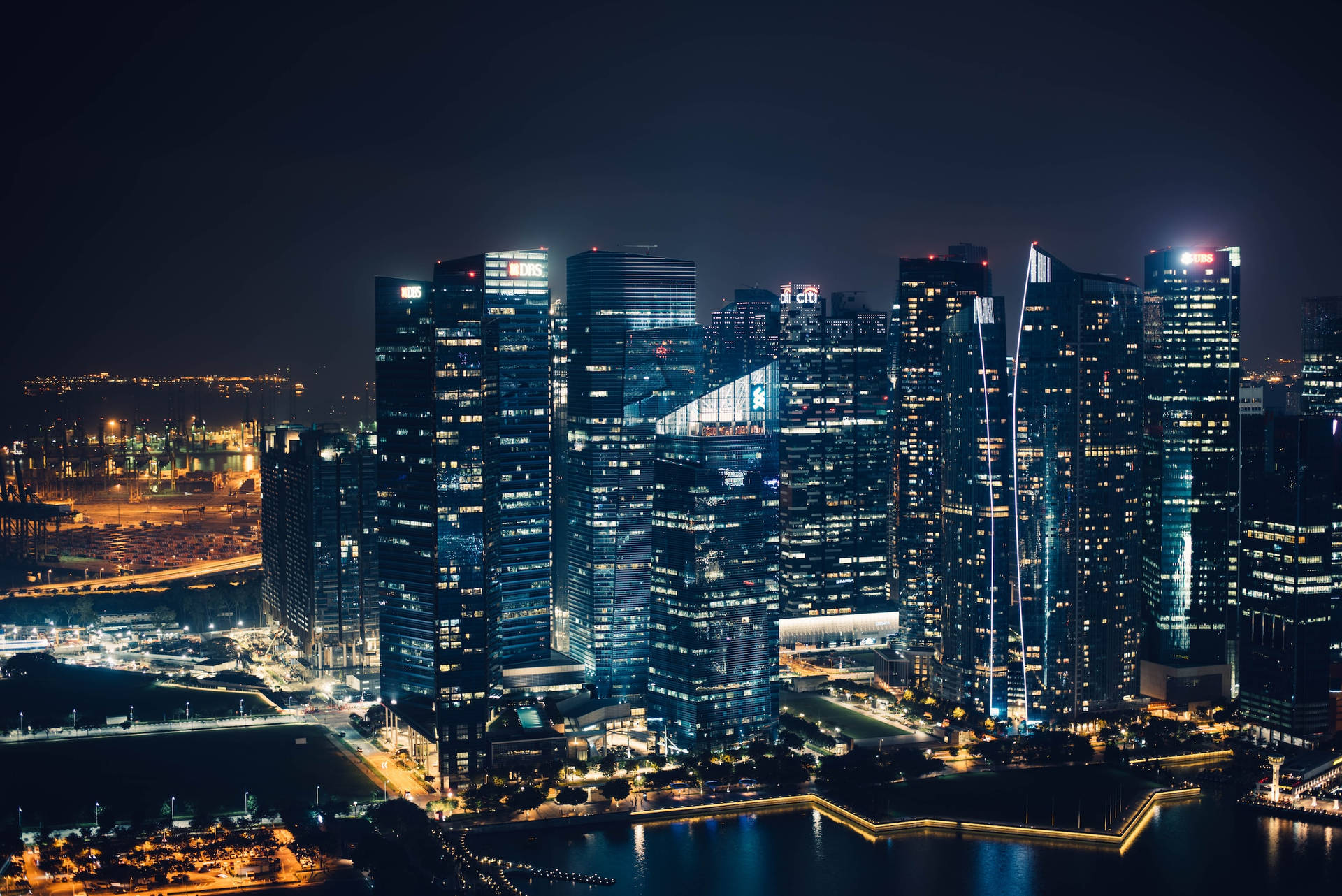 Mesmerizing City Night Showcasing The Reflective River Background