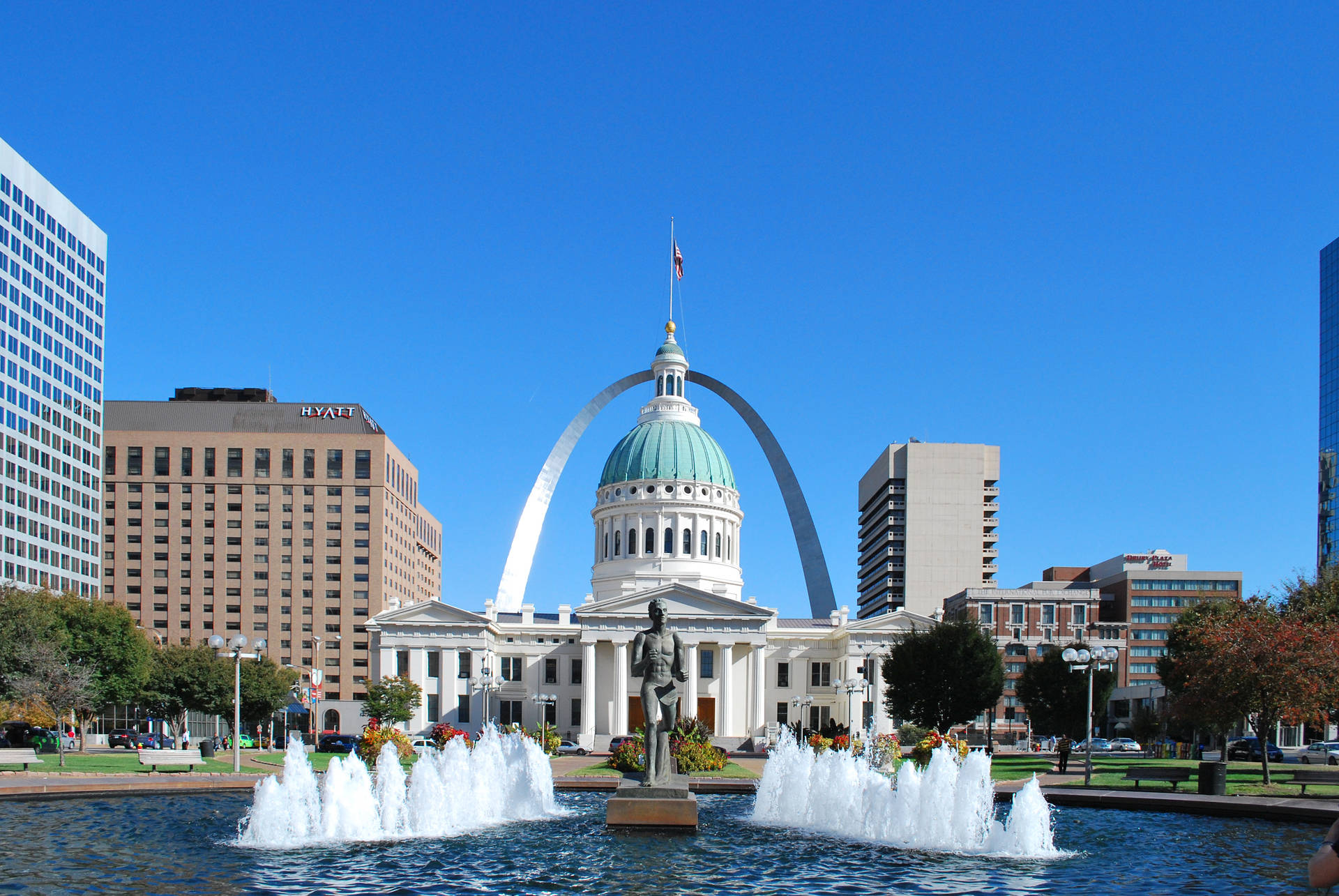 Mesmerizing View Of The St. Louis Arch With A Glistening Fountain In Foreground Background